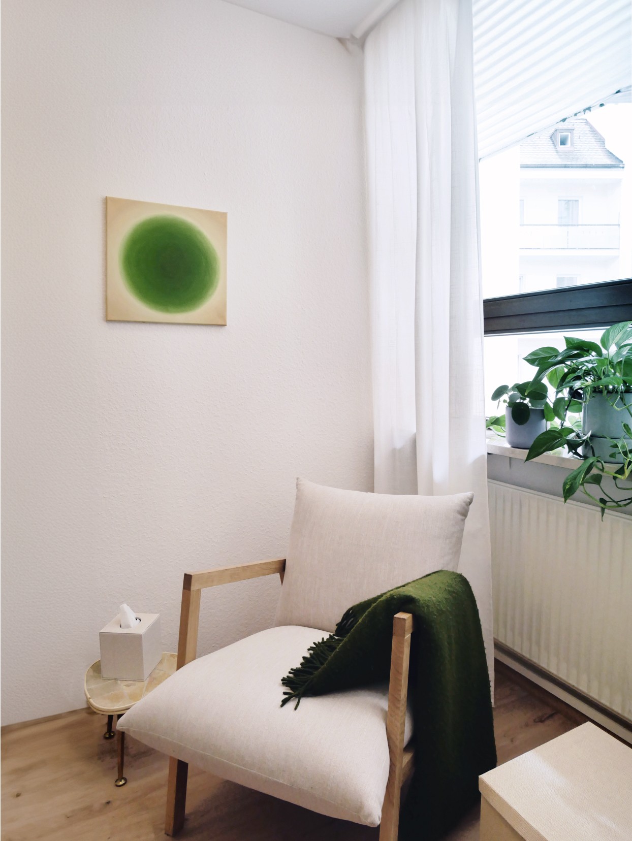 Gemütlicher Sessel mit Decke in lichtdurchflutetem Raum