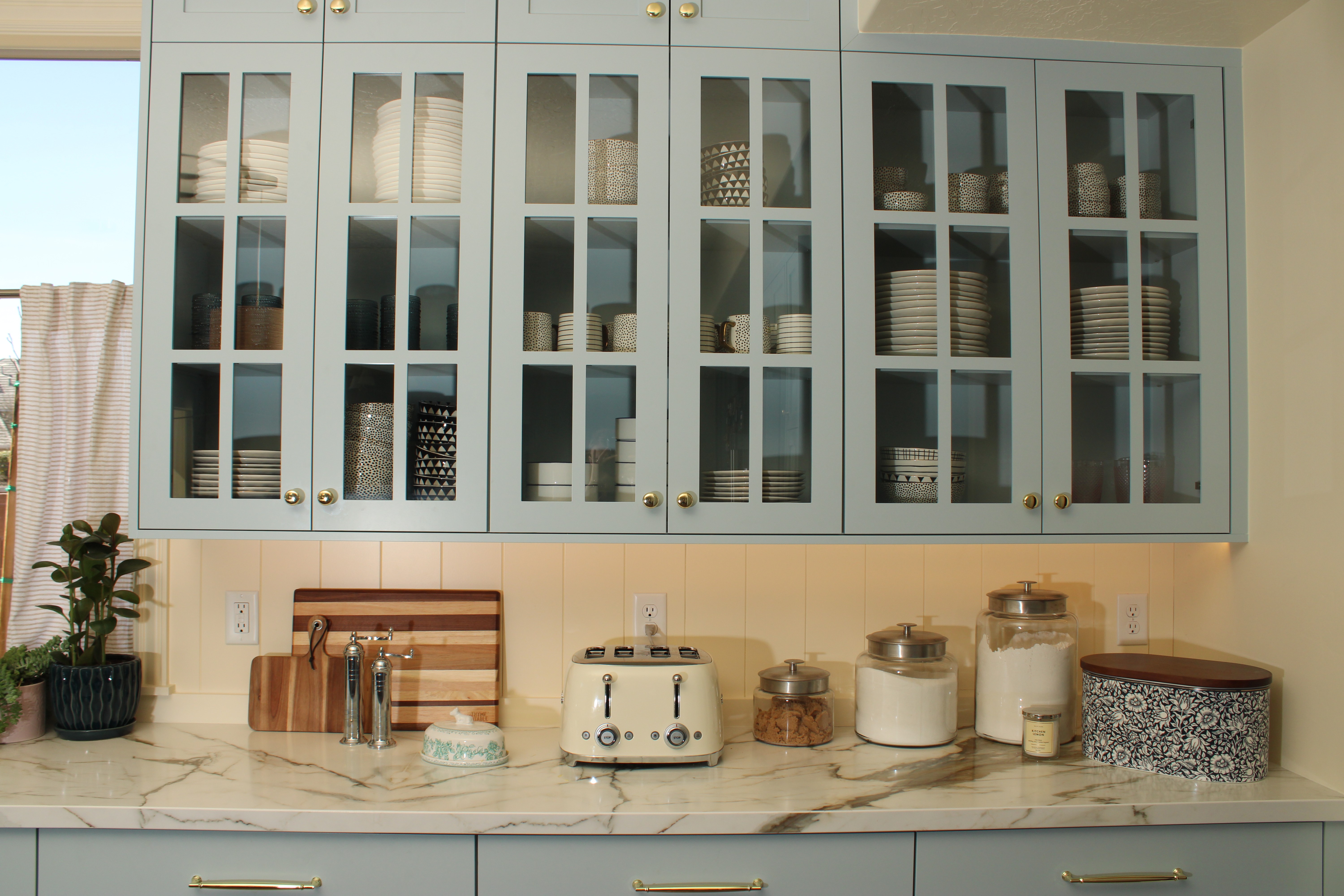 Custom kitchen in a Southern Utah home featuring blue cabinets with glass-front upper cabinets and countertops with subtle movement, combining style and functionality.