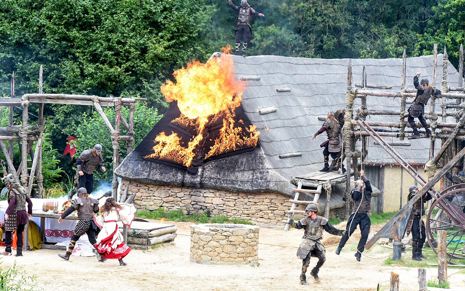 Viking reenactment with actors and burning roof at Puy du Fou, France.