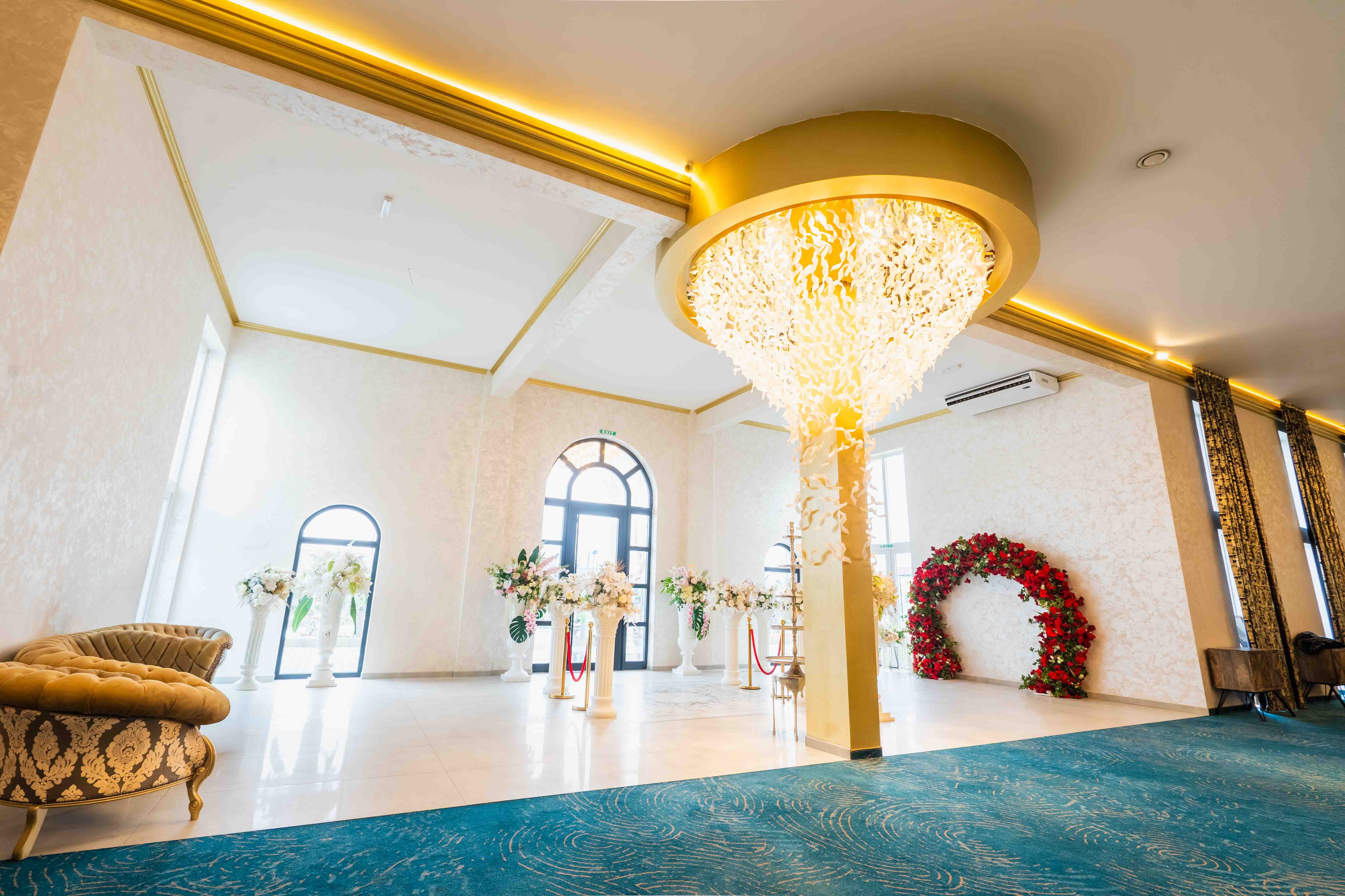 Modern kitchen with a wooden dining table, white chairs, and a hanging light fixture above.