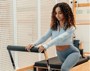 oung woman exercising at a fitness studio, representing health insurance for under 35s