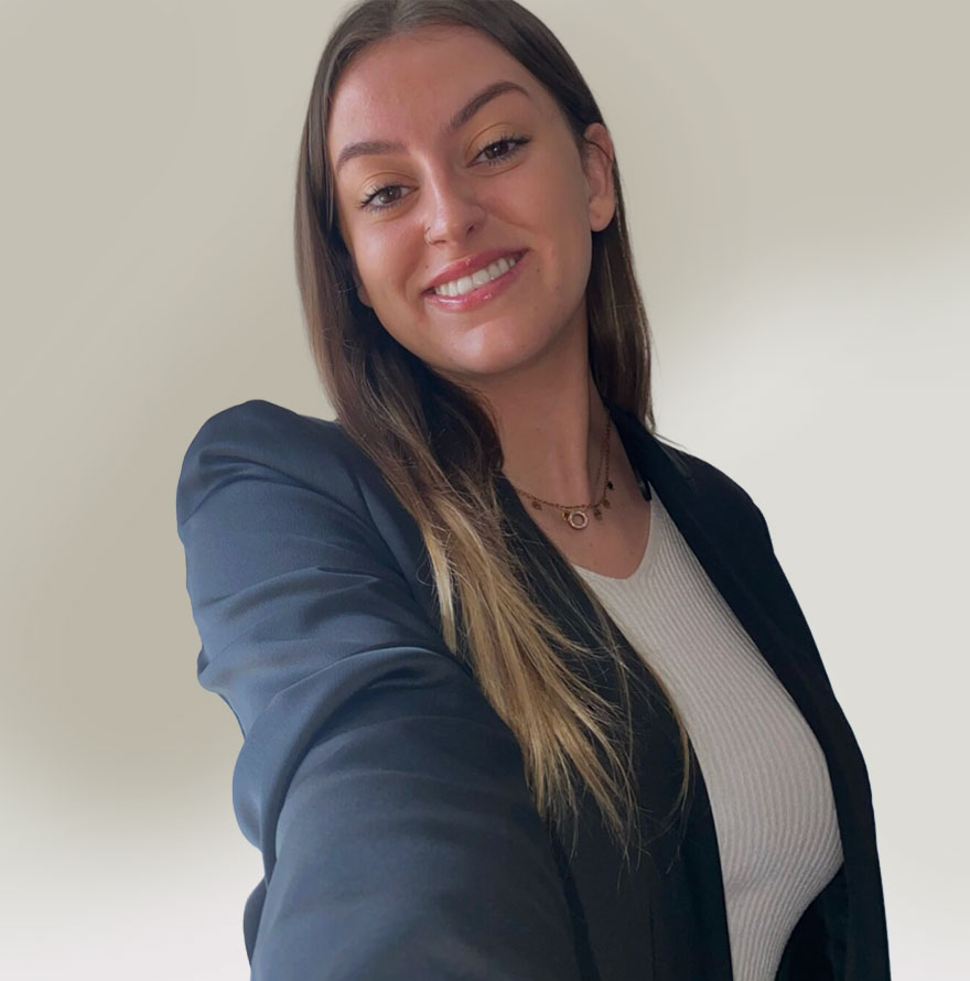 A woman with curly hair, wearing round glasses and a white t-shirt, smiling gently.