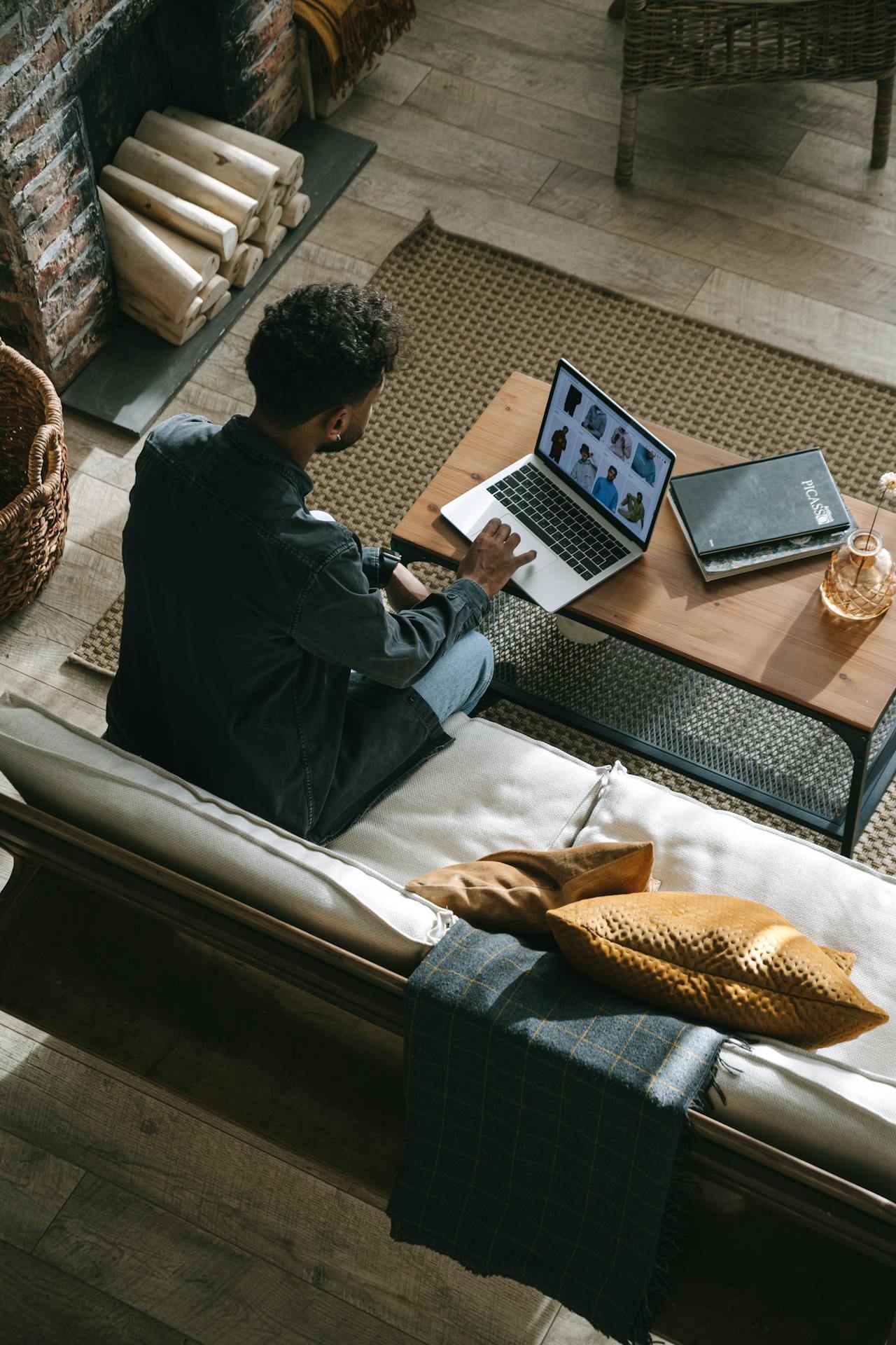 a perosn sitting on a sofa and using laptop