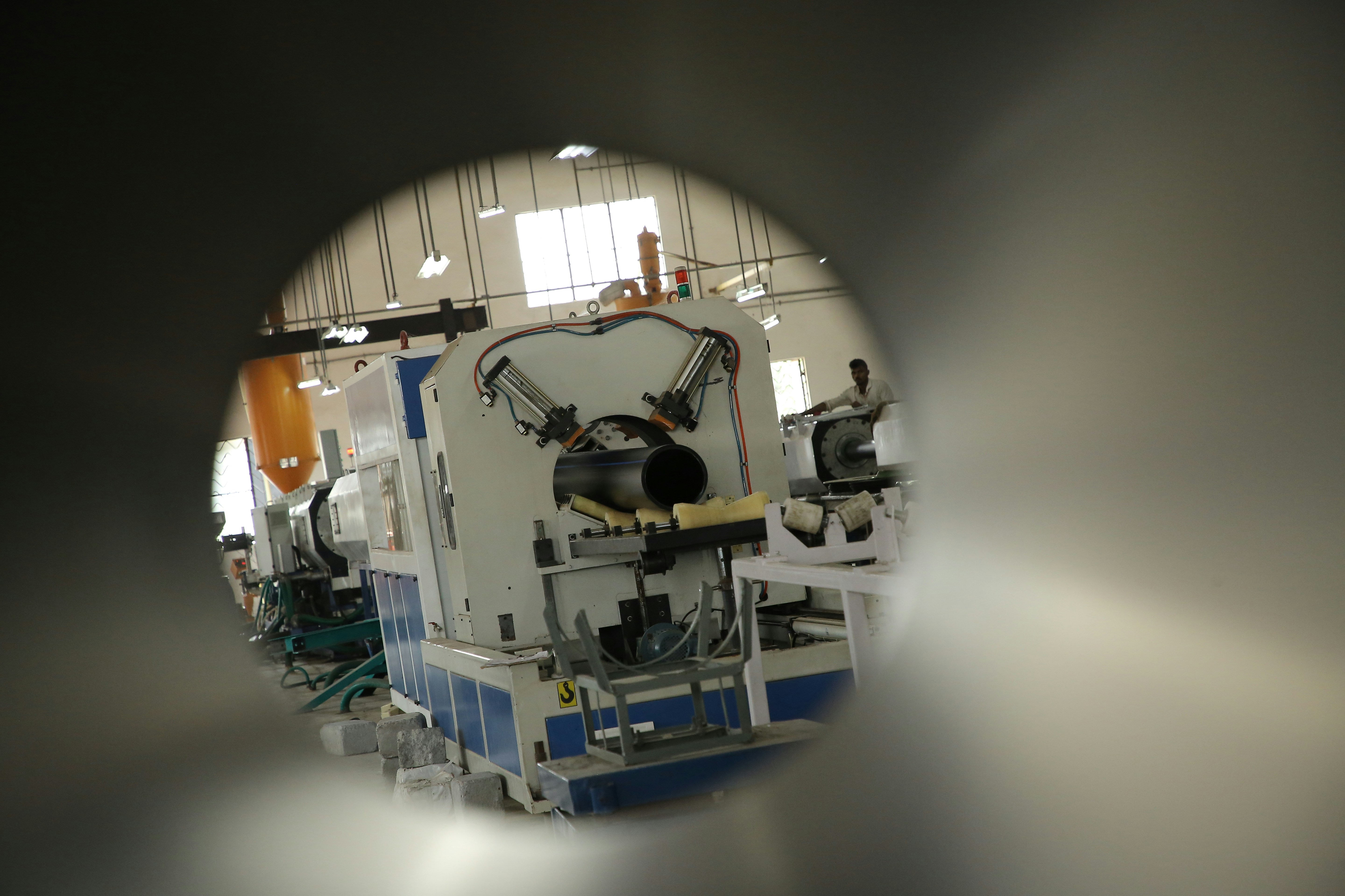 a machine in a factory with a man working on it