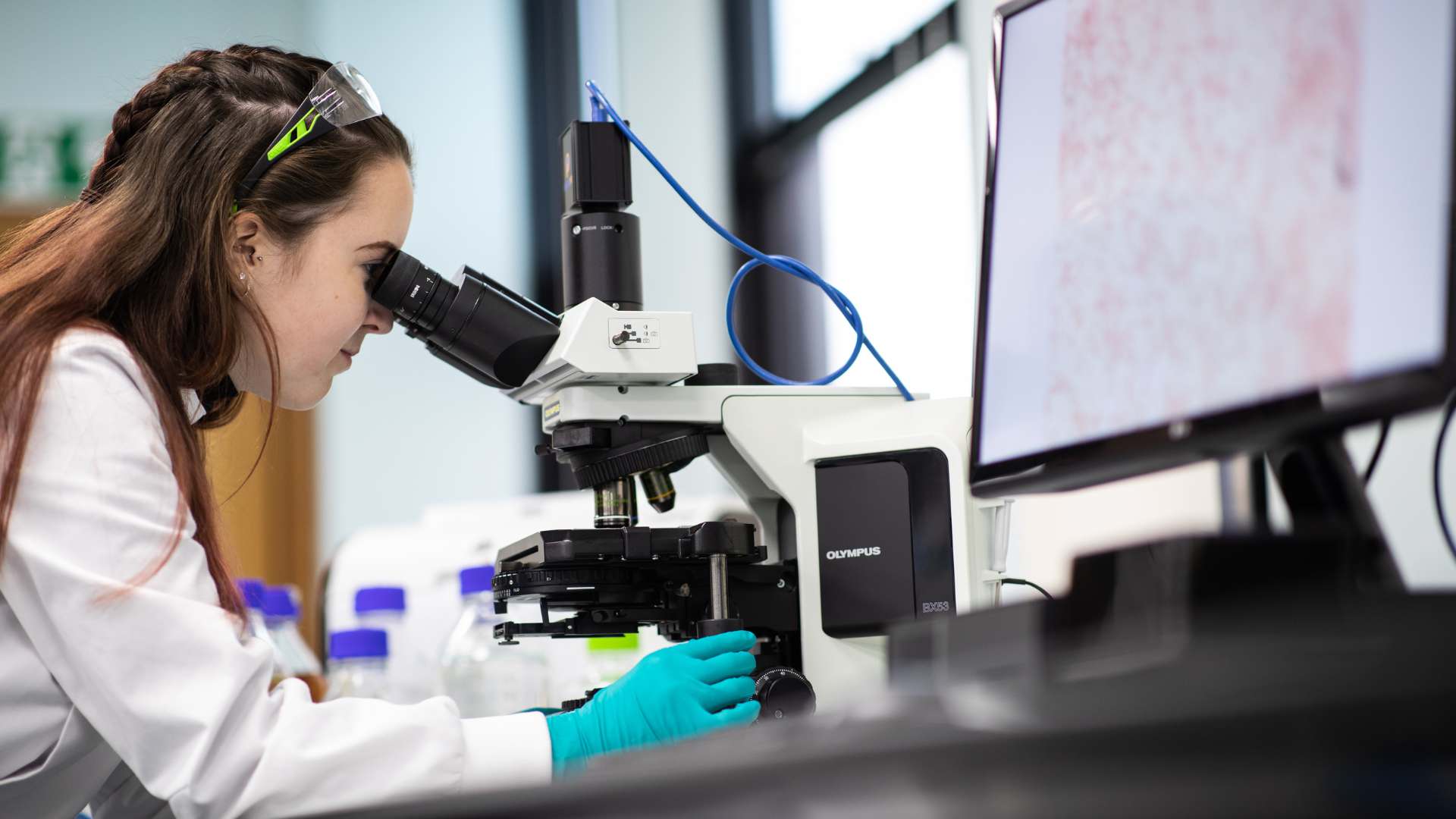 A CPI scientist looking through a microscope.