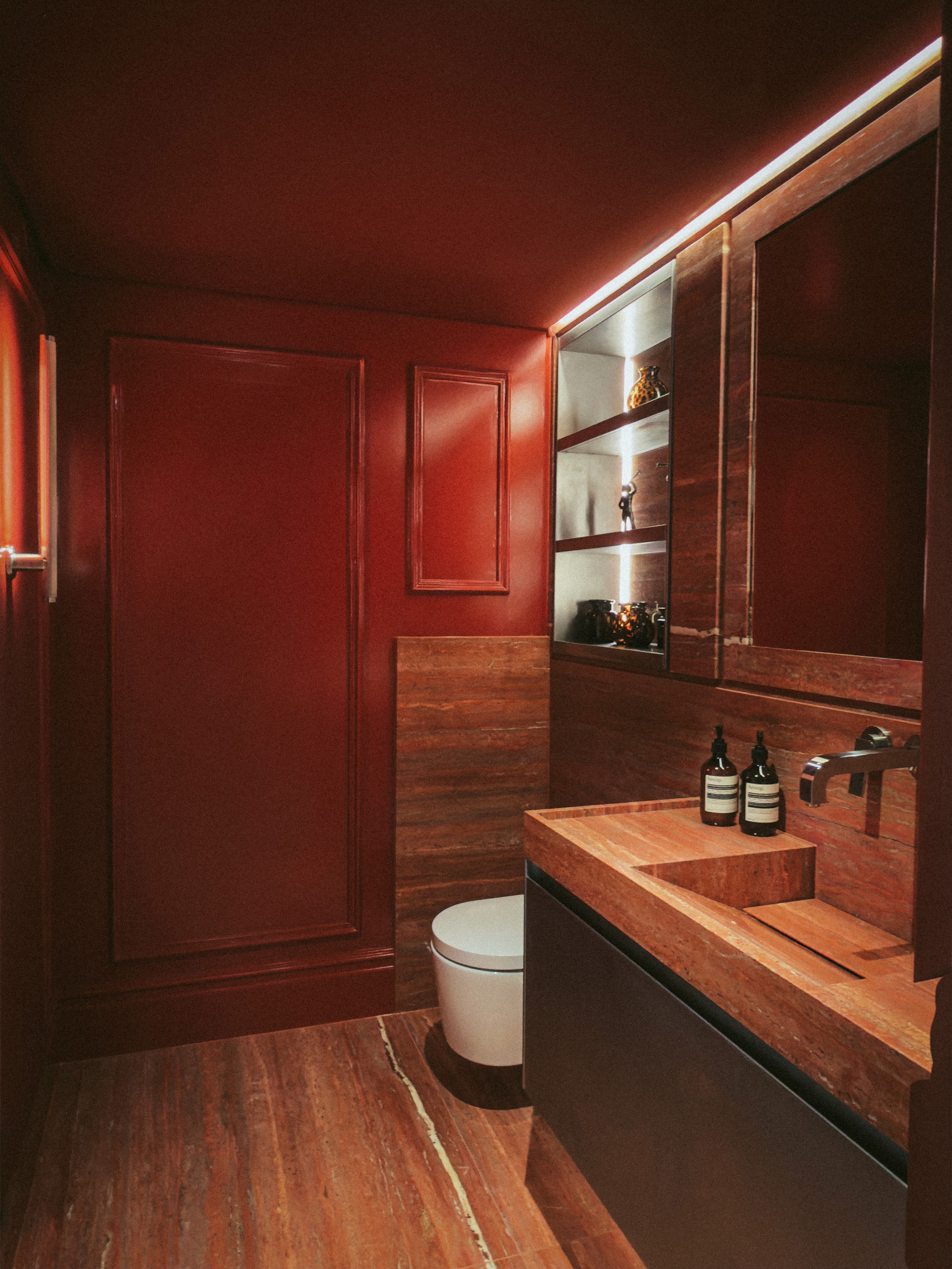 Deep red bathroom interior with red travertine flooring and stone sink