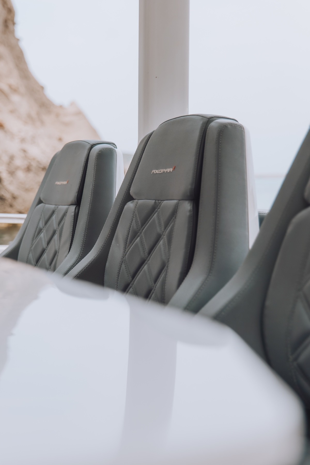 Luxury gray quilted seats with headrests inside the Axopar 37 yacht cabin, featuring premium upholstery and modern design.