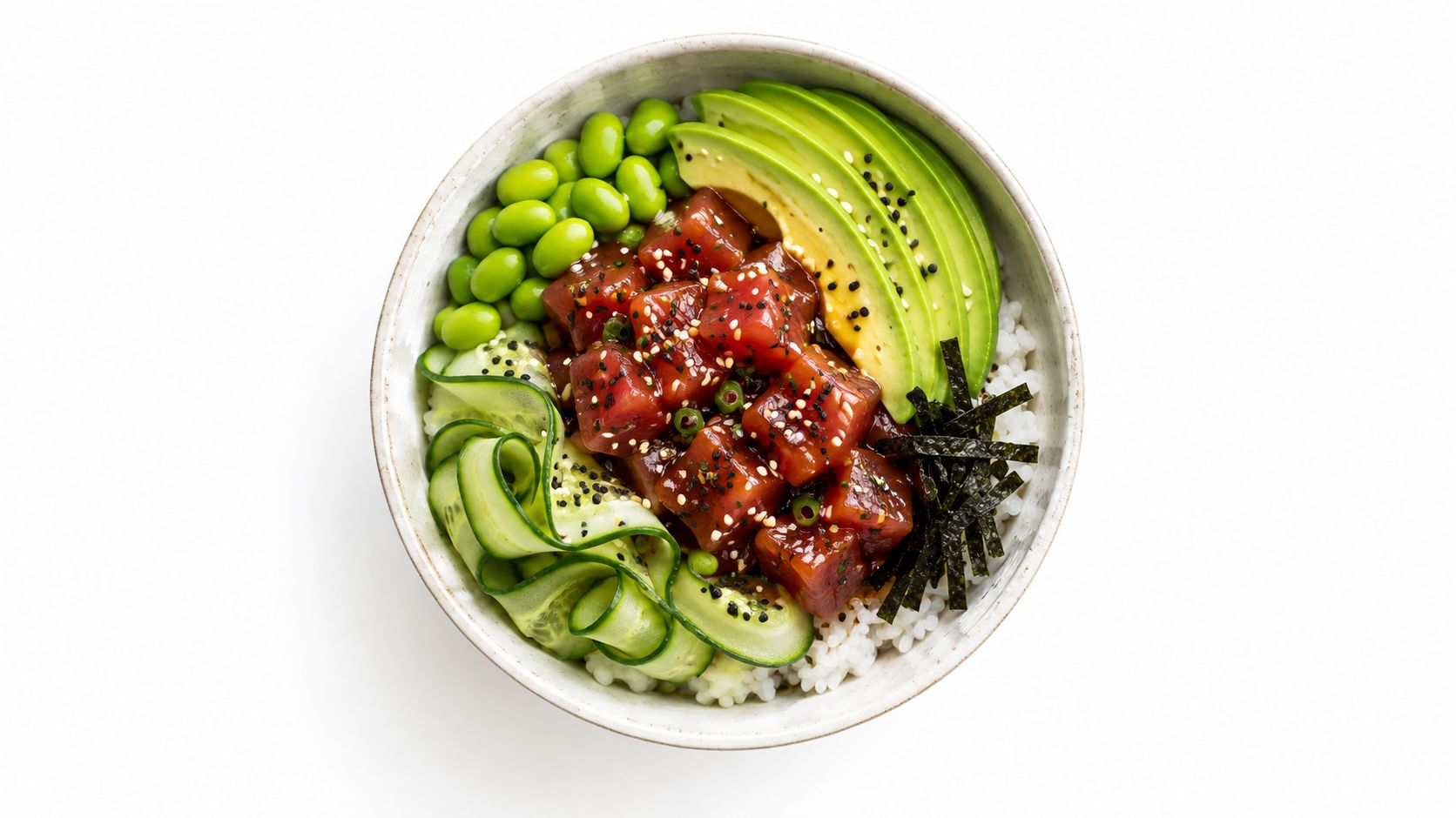 Un delicioso tazón de poke saludable con atún fresco, aguacate, edamame, pepino y arroz sobre fondo blanco.
