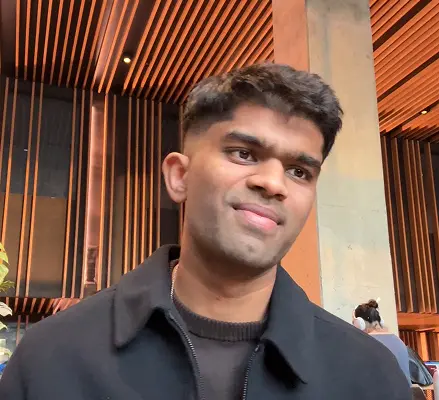 Man in a black jacket standing in a modern cafe interior