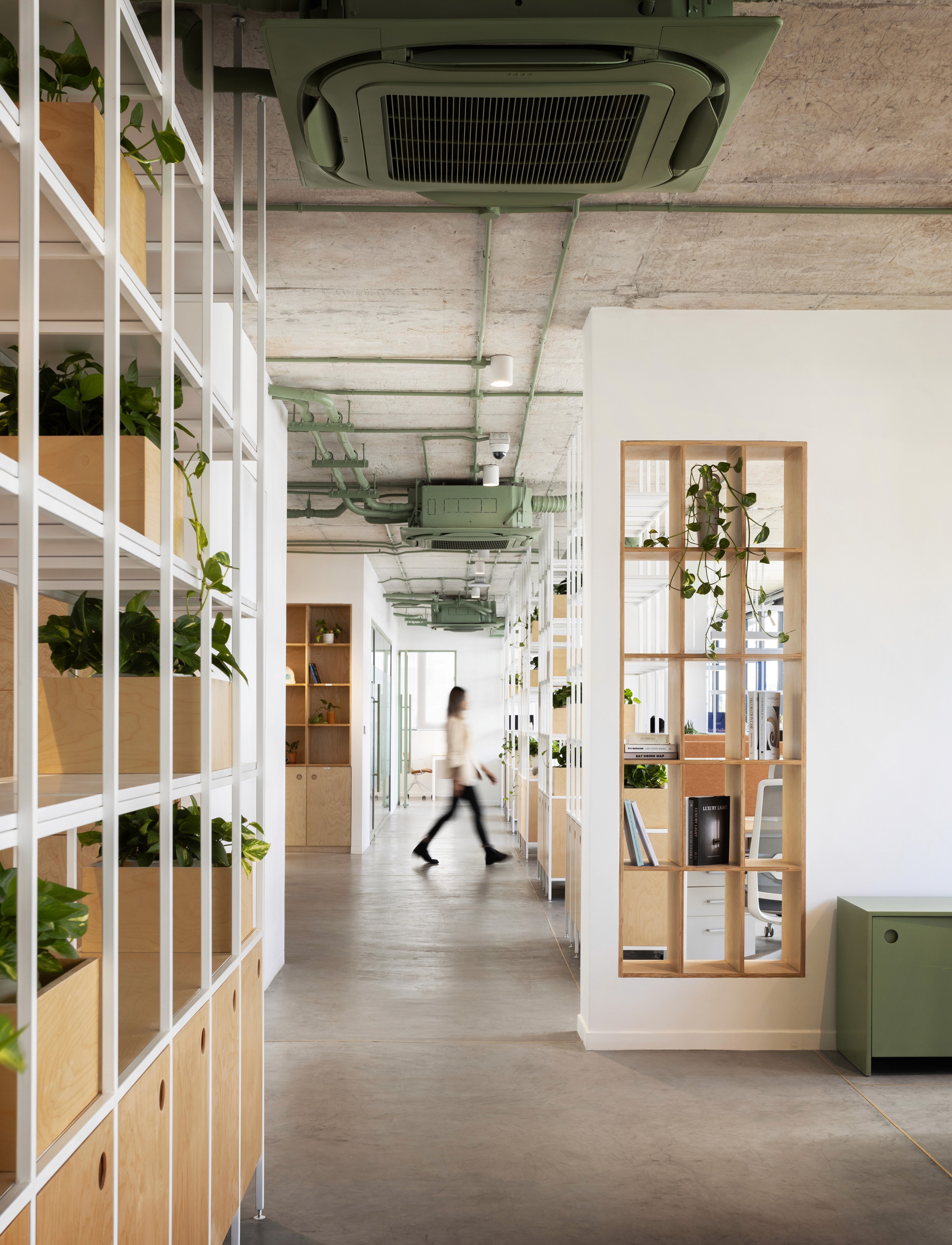 Interior design of a collaborative workbench area at ULS, featuring a long wooden table with multiple computer setups, ergonomic chairs, and industrial-style finishes.