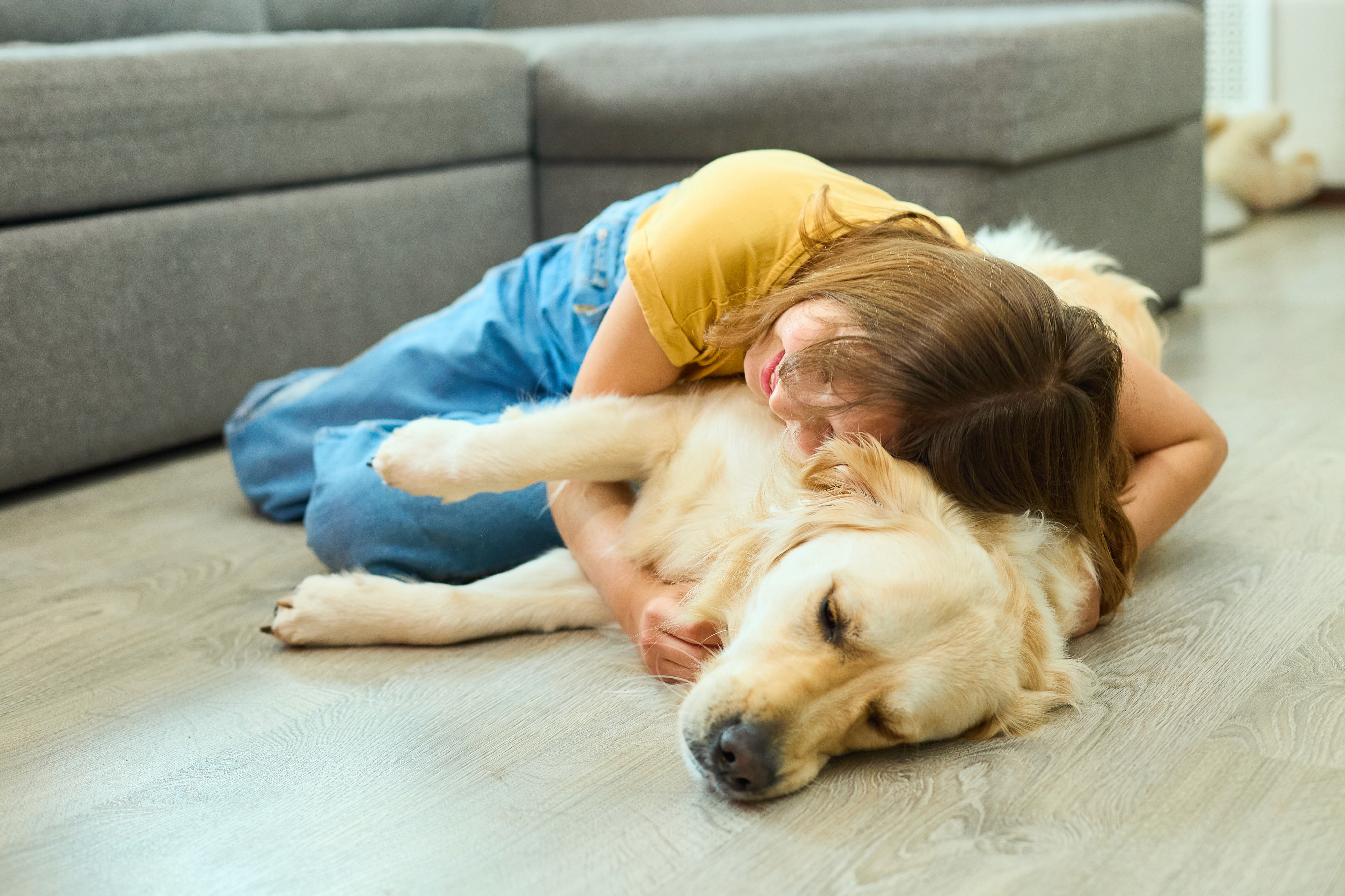 Girl cuddling her dog on a level living room floor in a Brisbane home — the kind of everyday moment parents want without worrying about slips or uneven boards.
