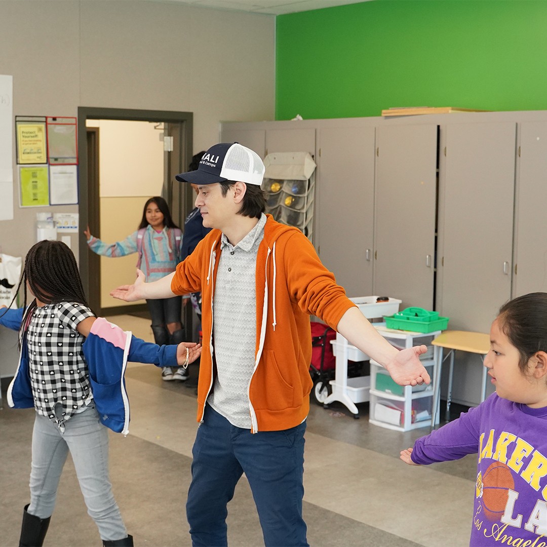 Theater instructor leading spontaneous acting activities in after school improv session