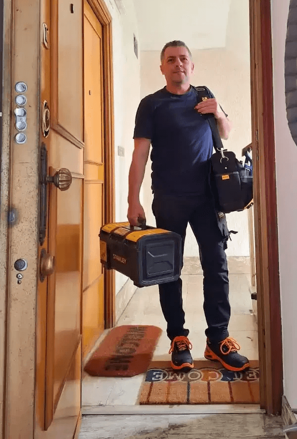 Titolare della S.A.Multiservizi Roma davanti appartamento con strumentazione tecnica e certificati