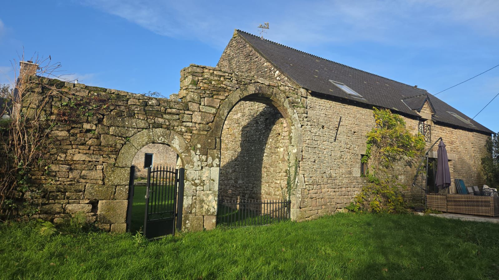 A cozy garden corner featuring potted herbs, a wooden bench, a watering can, and a wicker basket with towels, creating a serene and natural outdoor vibe.