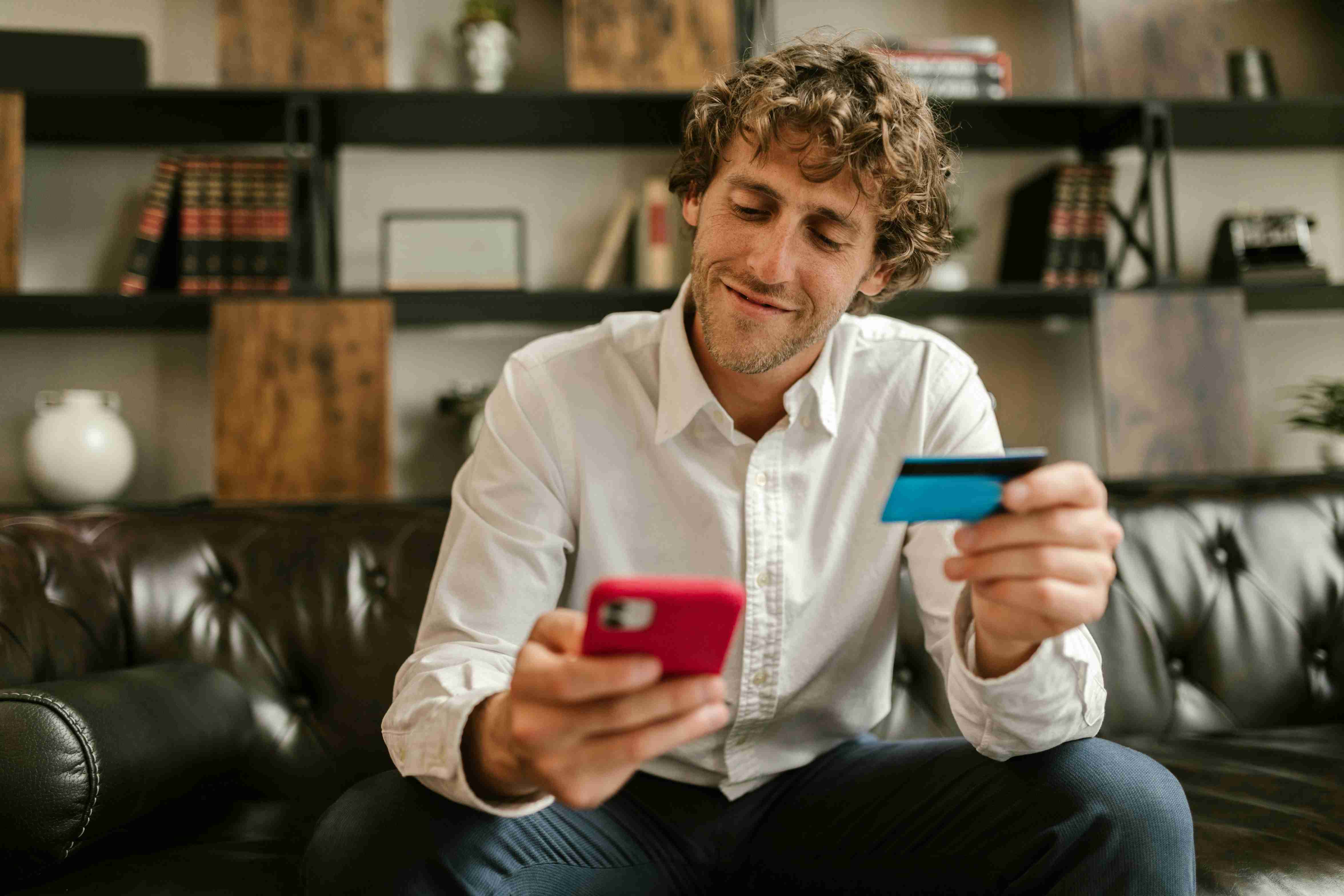 man holding card and a phone making a purchase