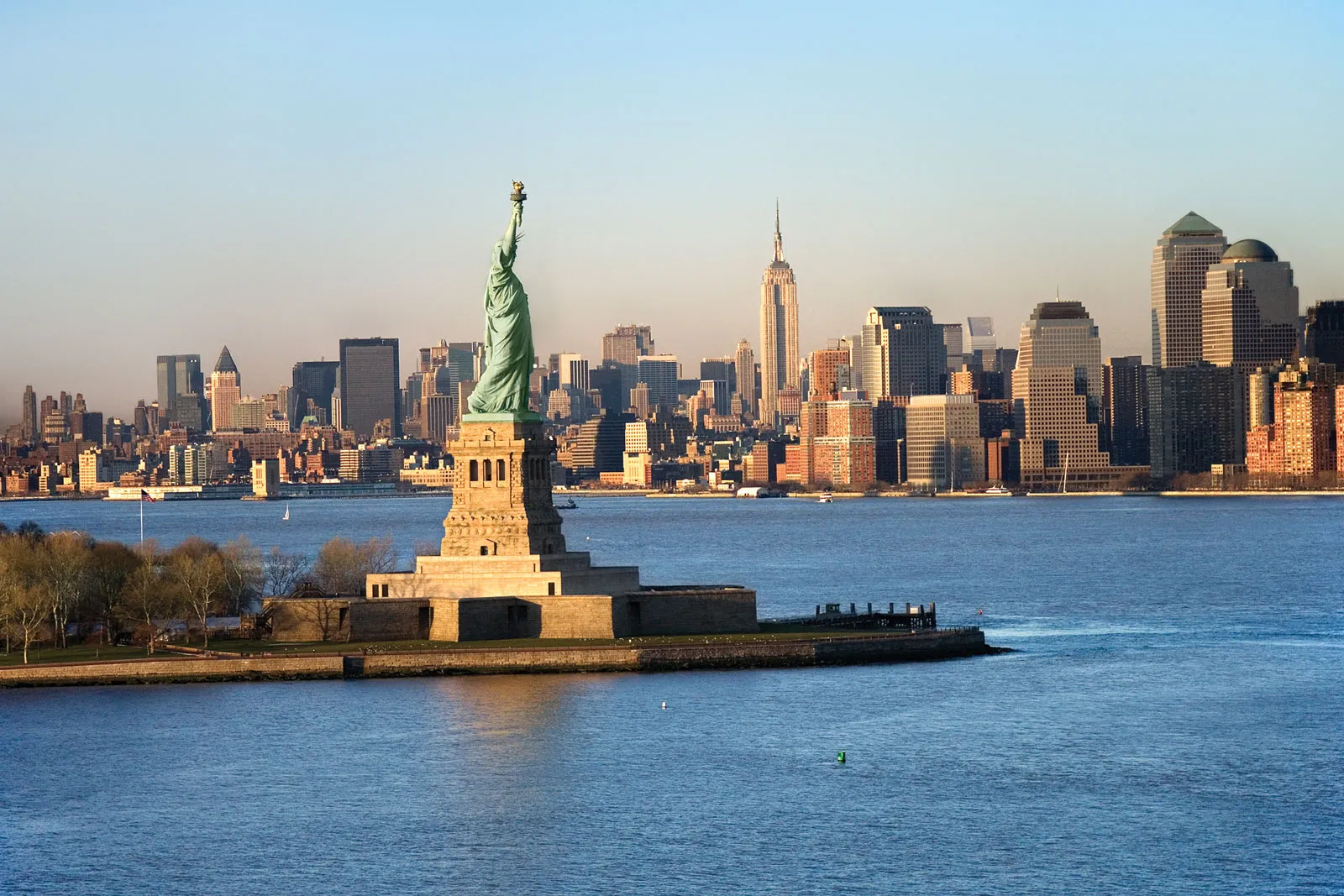 Photo of Statuo of Liberty with New York skyline behind it