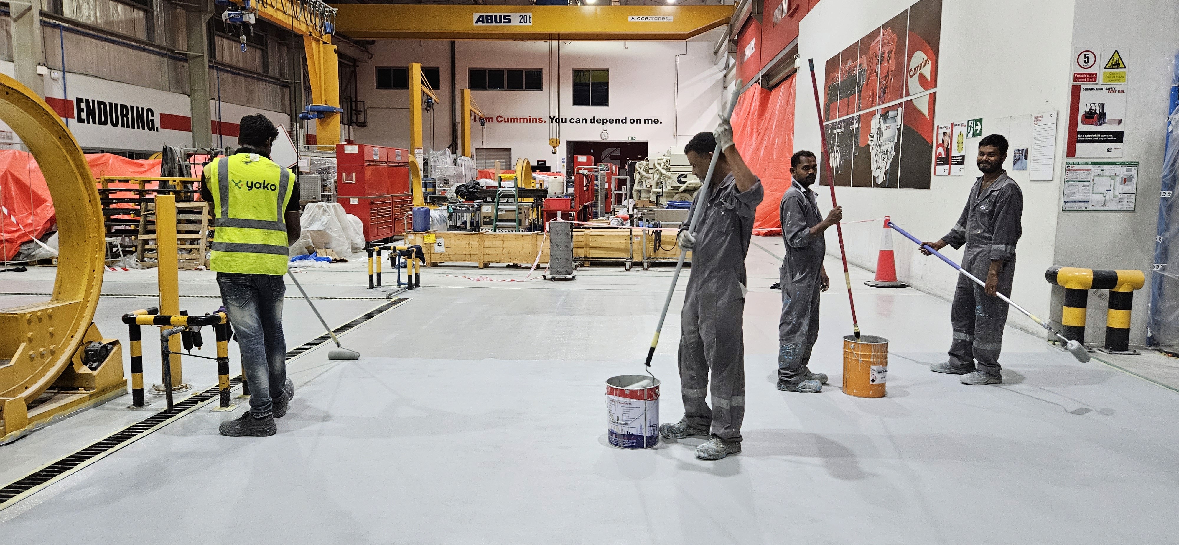 Yako team applying industrial floor coating at a manufacturing facility