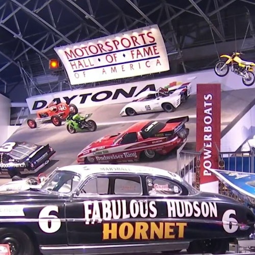 Udstilling med klassiske racerbiler, motorcykler og en motorbåd i Motorsports Hall of Fame of America.