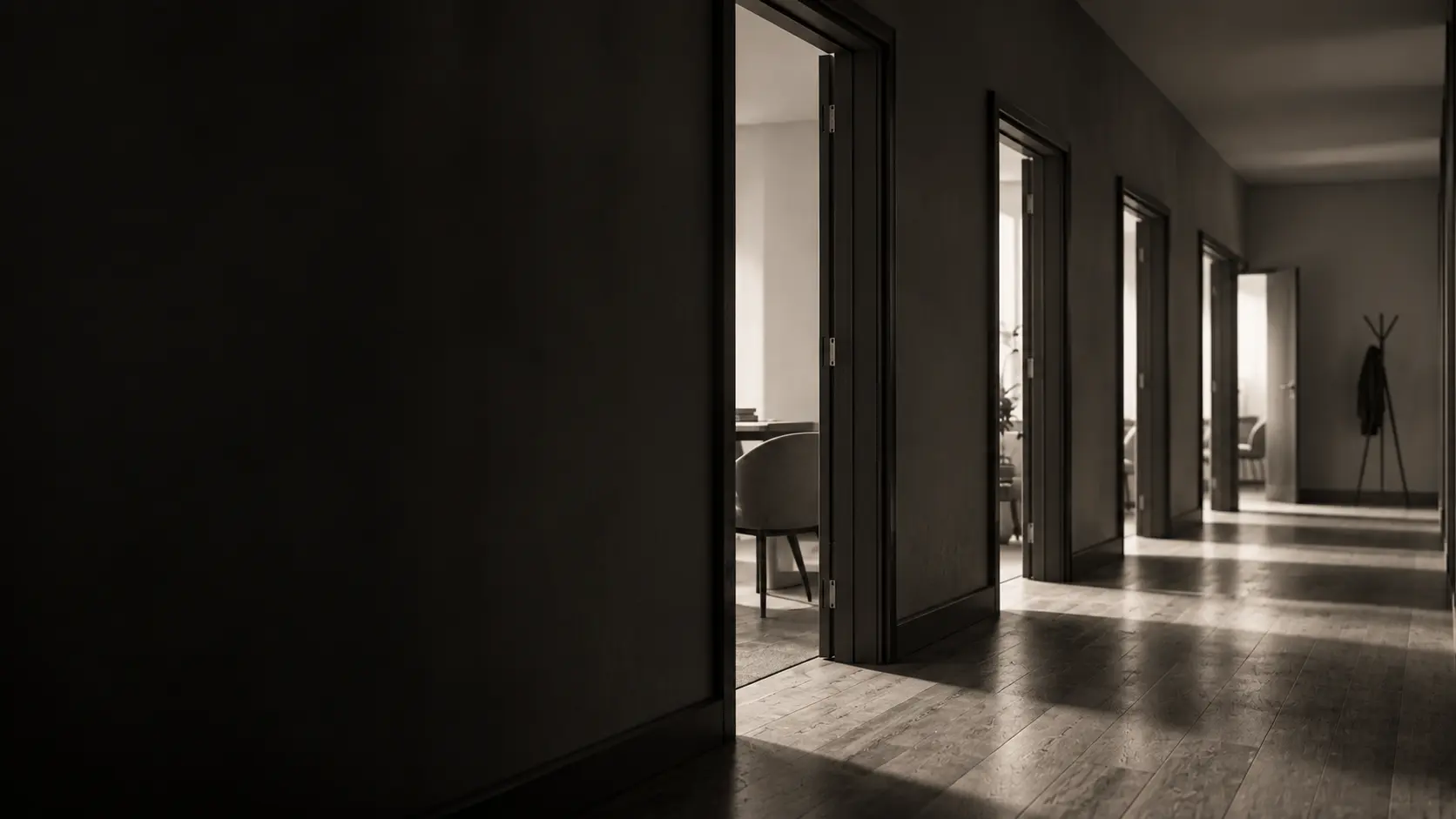 A quiet office corridor with every door open and daylight falling across the floor
