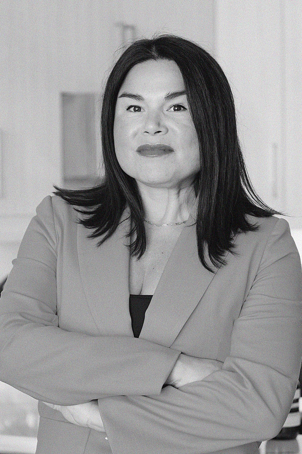 A young man with dark hair smiles at the camera, set against a modern indoor background.