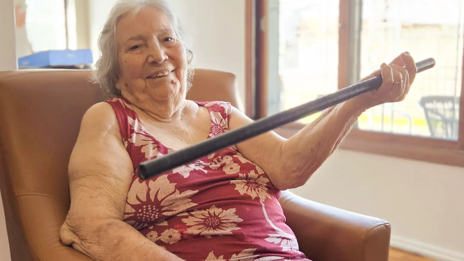 Mulher idosa sorrindo e bem cuidada no Residencial Nova Era, representando alegria e qualidade de vida.