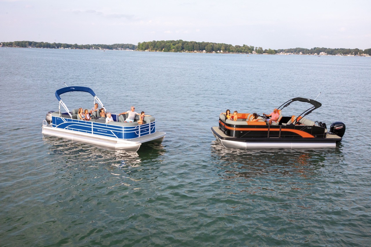 A pontoon and tritoon on a lake