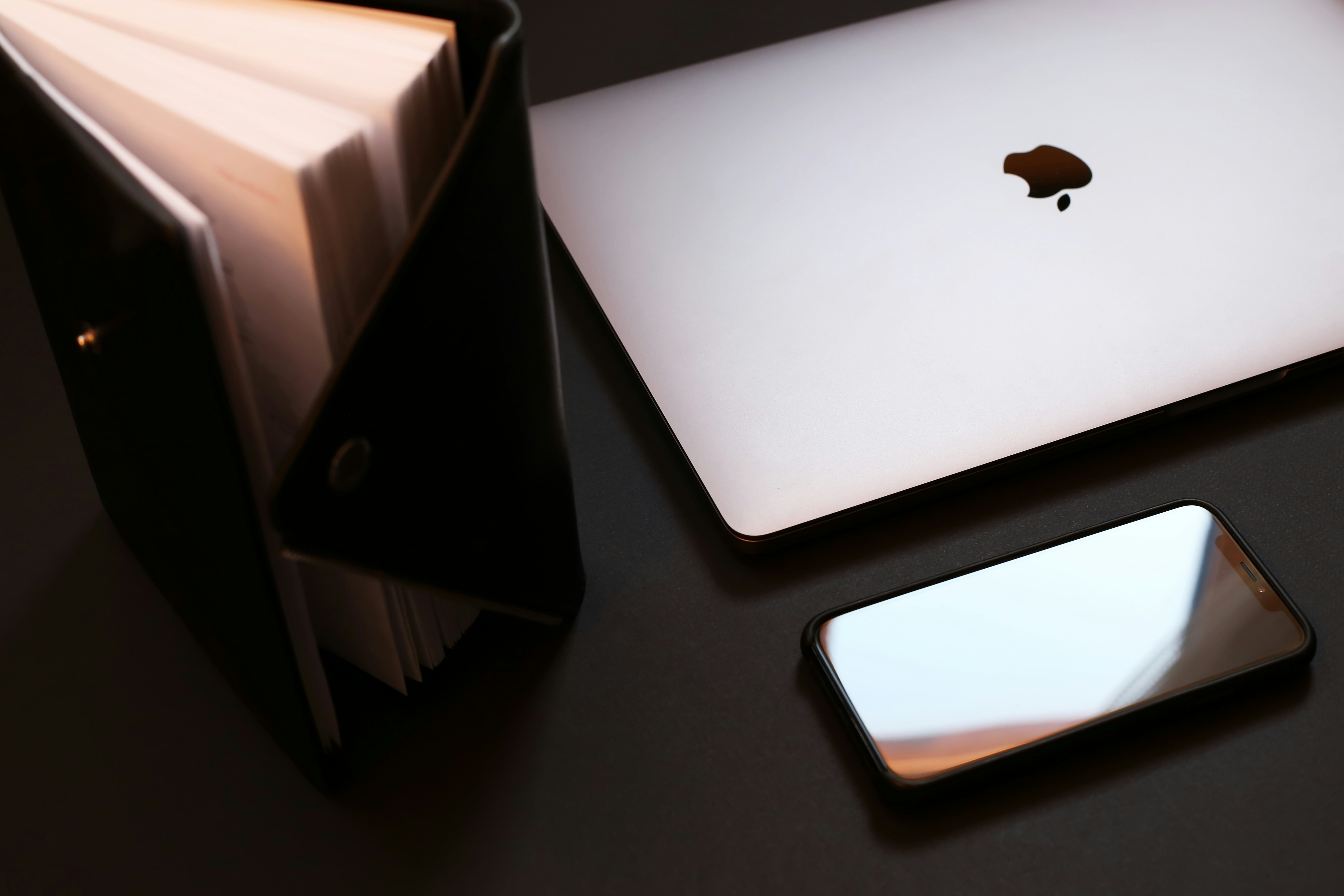 silver macbook on black table