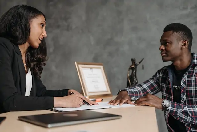lawyer speaking with a person in a plaid shirt as they prepare a case for the landlord and tenant board