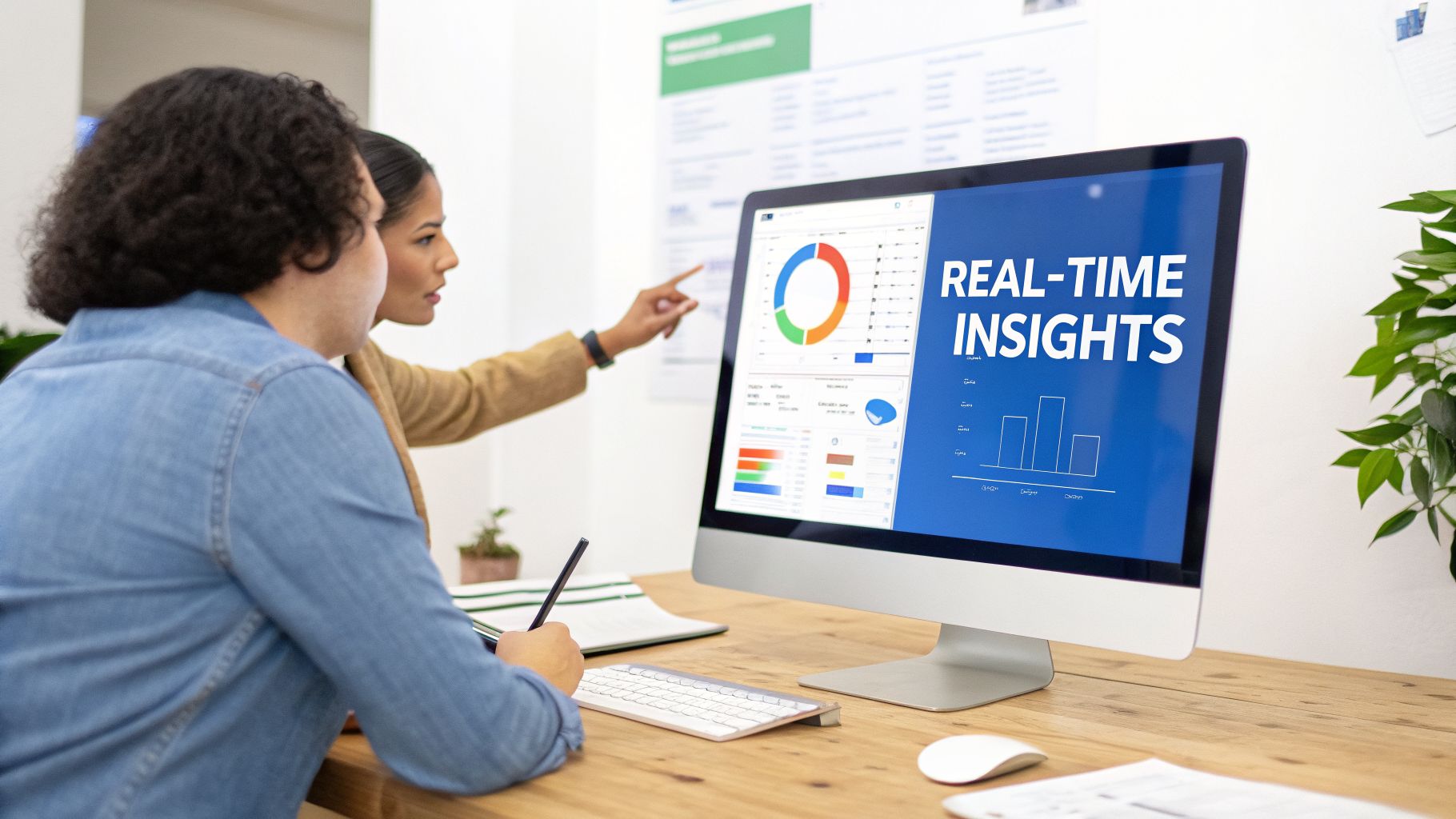 Two professionals analyze real-time data insights on a computer dashboard in an office setting.