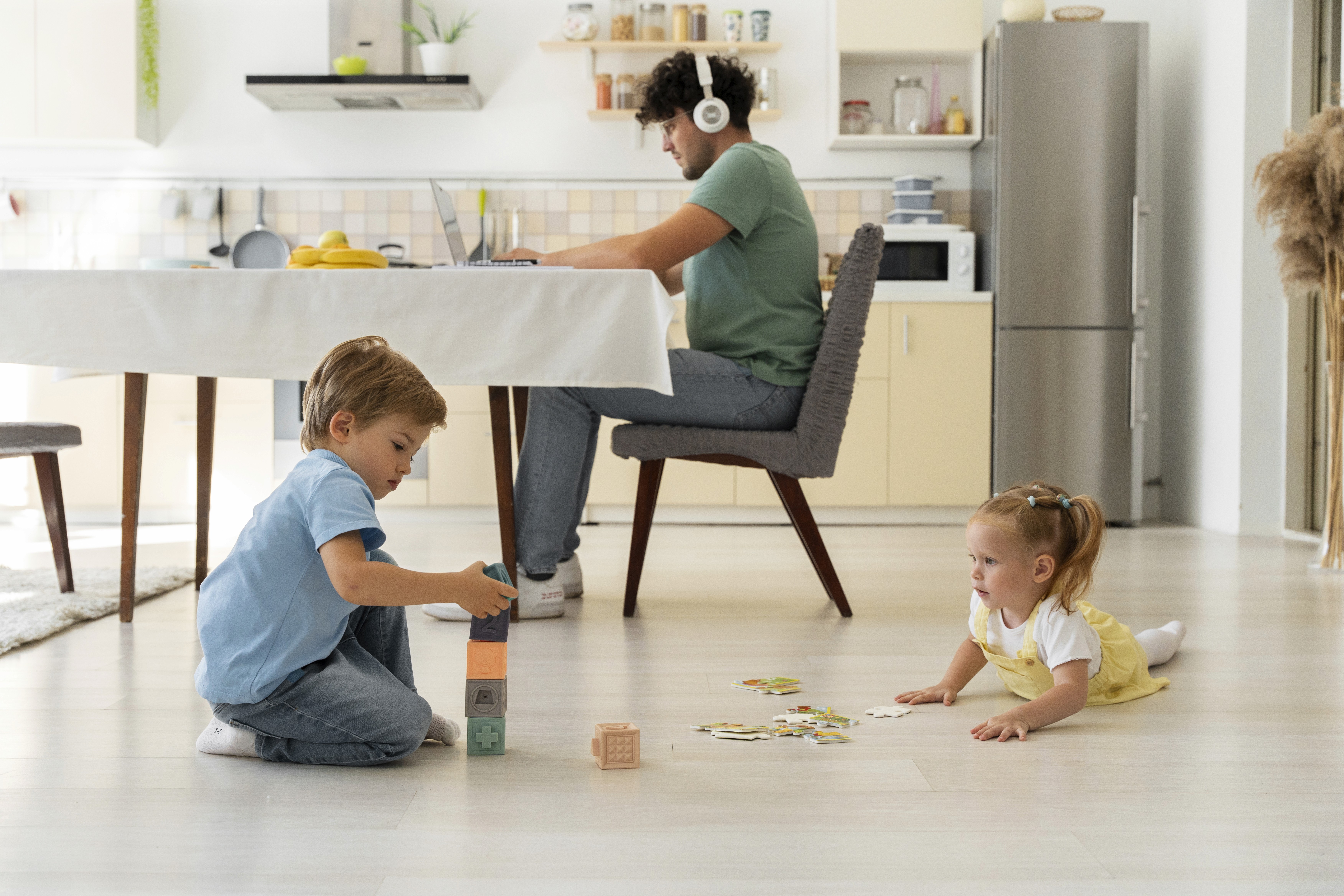 Children play safely on LUXO’s light wood-look hybrid flooring while a parent works nearby, showcasing a durable, easy-clean, and kid-friendly surface ideal for modern Australian homes.