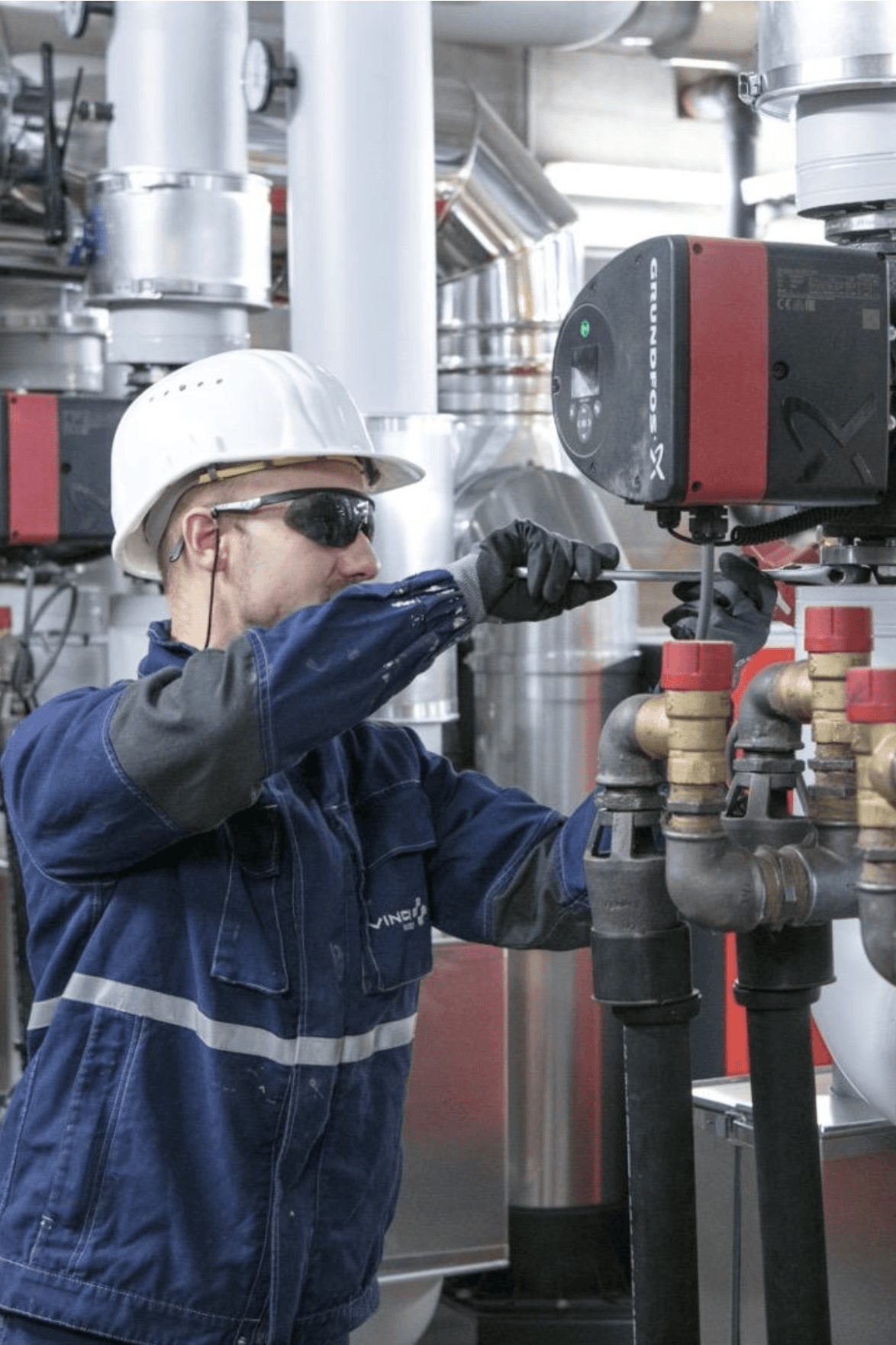 Maintenance worker with protection helmet working on machinery