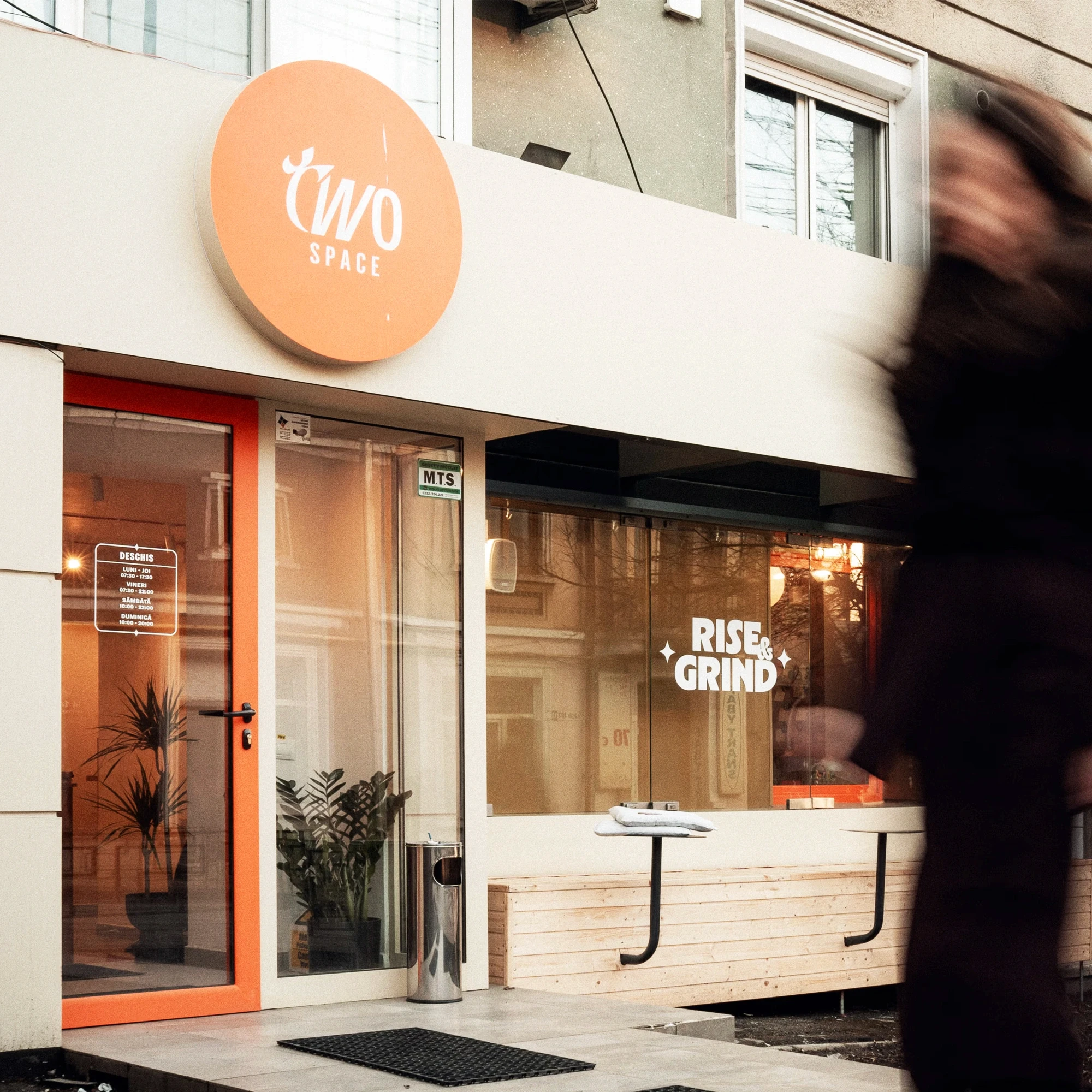 Intrarea cafenelei TwoSpace cu tâmplărie colantată portocaliu reclamaă luminoasă, Iași