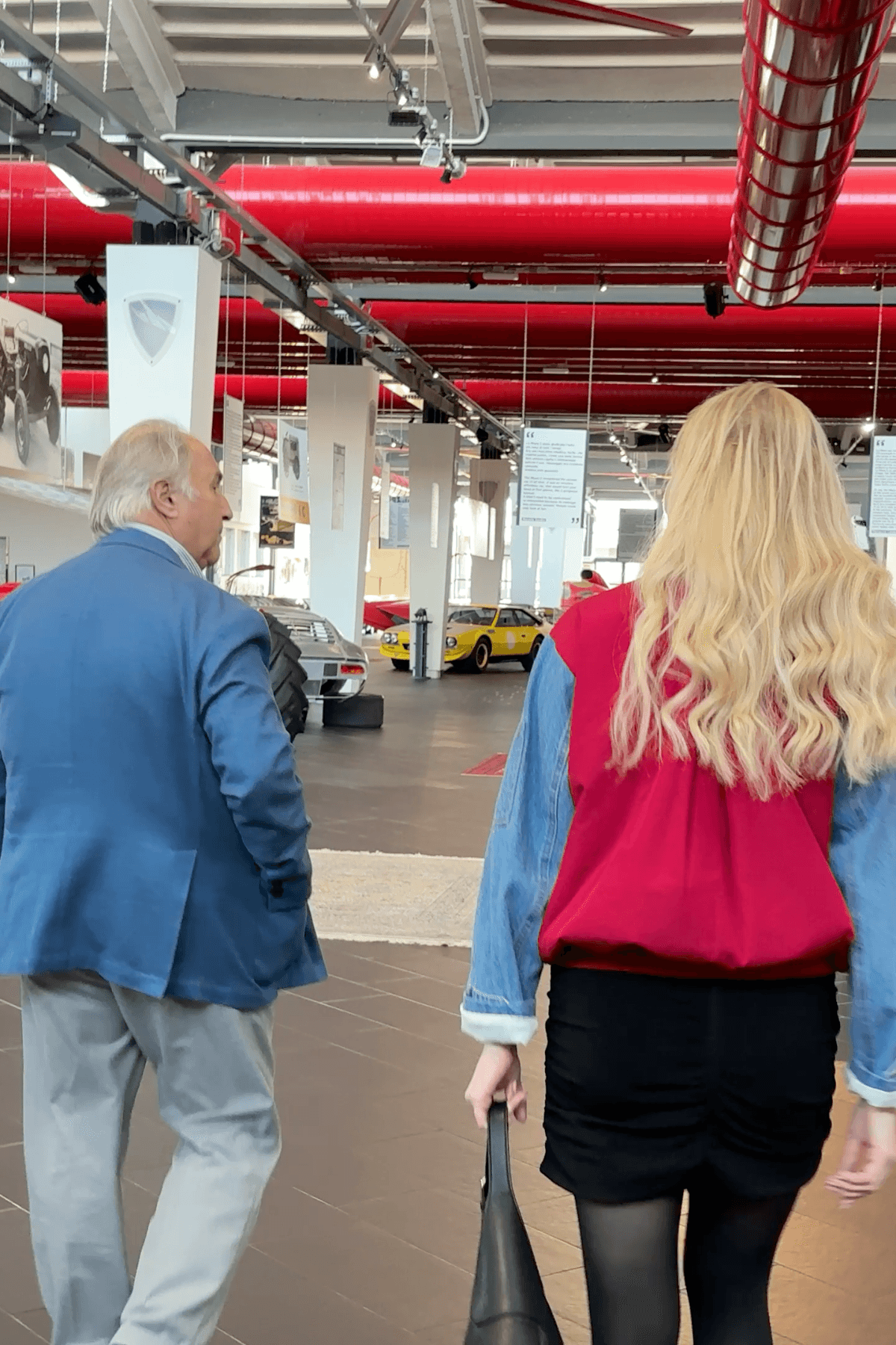 Tonino Lamborghini and Elena walking through the Museo Tonino Lamborghini with historic Lamborghini cars on display