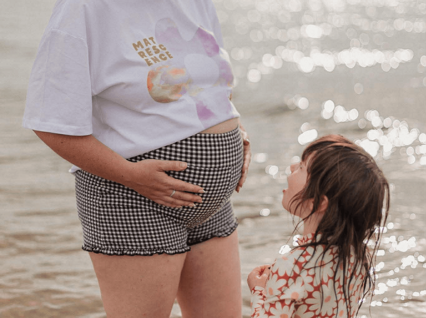 Pregnant woman's belly illuminated by sunlight.