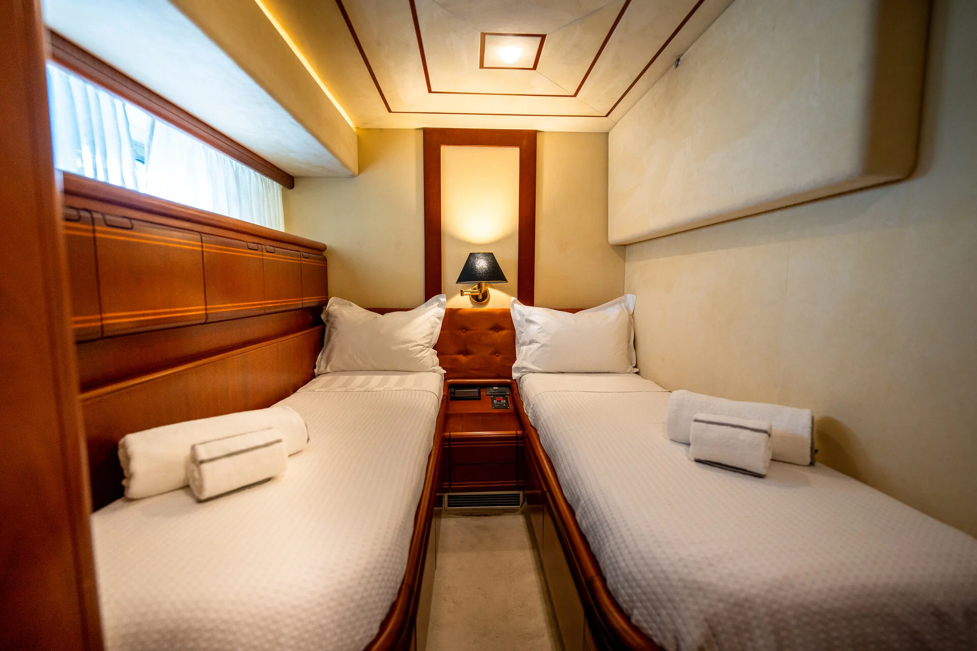 White Rock 36 speedboat with captain at helm cruising calm blue waters near Paros coastline with hills in background.