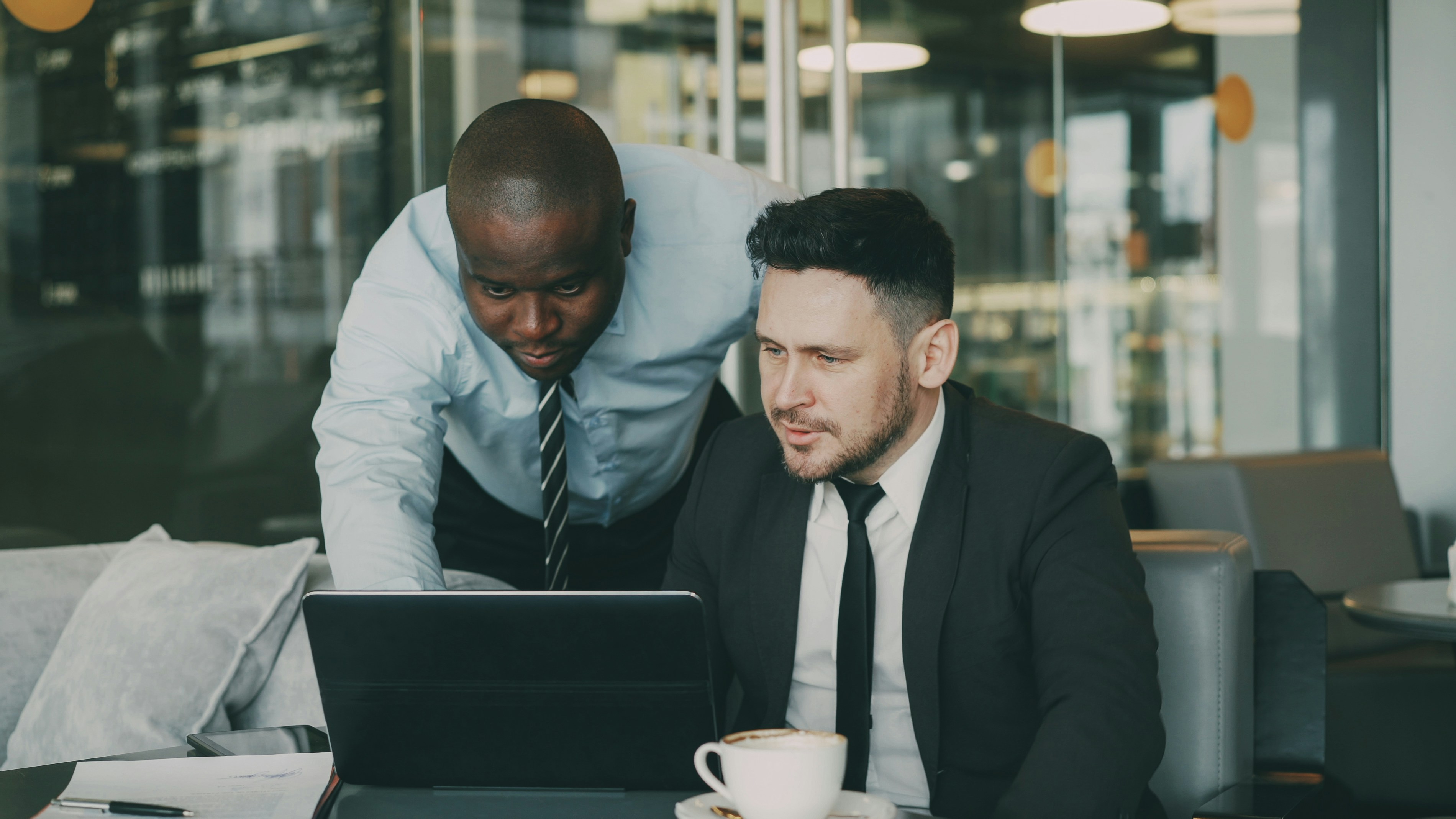 Two businessmen collaborating on a laptop