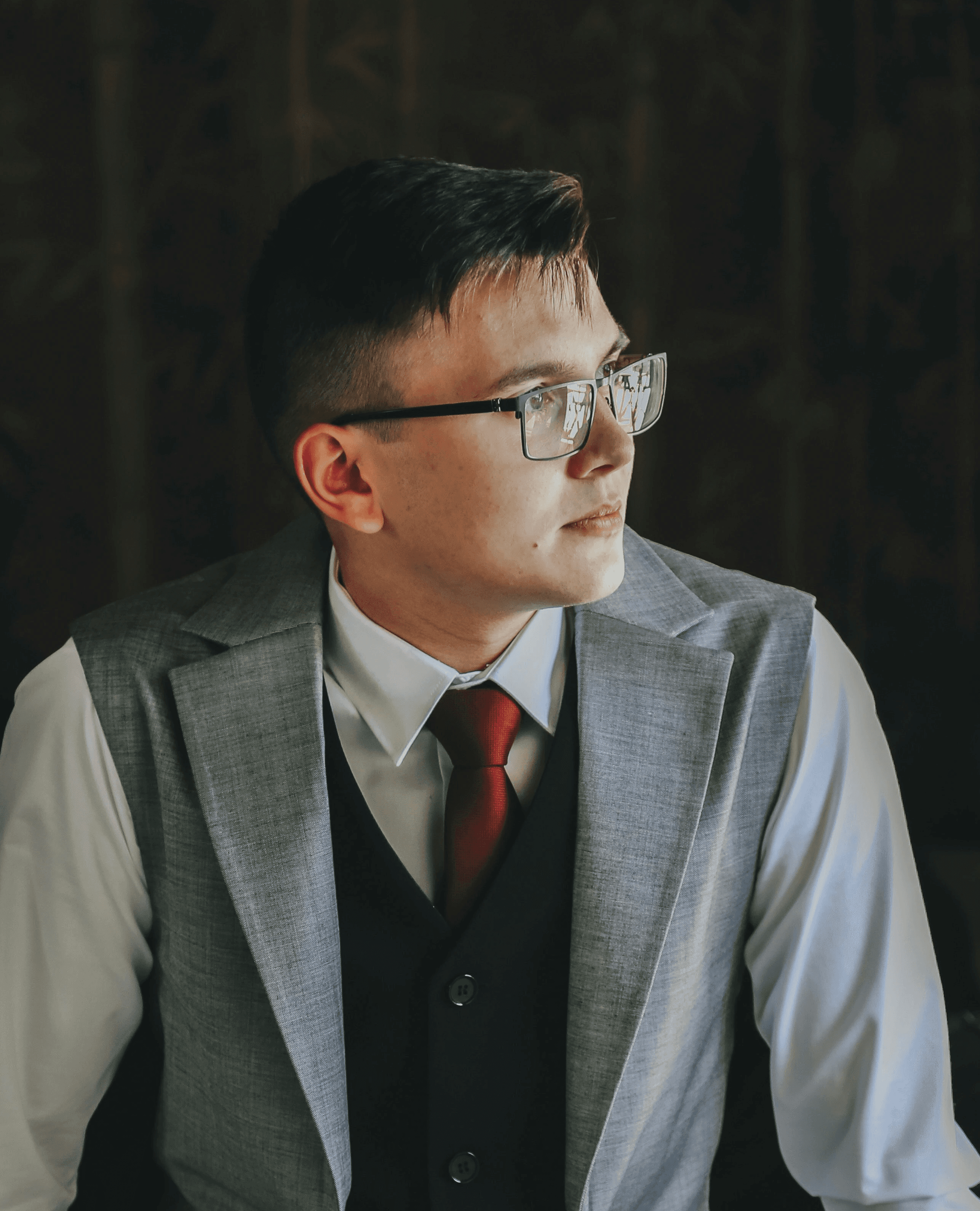 man in gray suit jacket wearing black framed eyeglasses