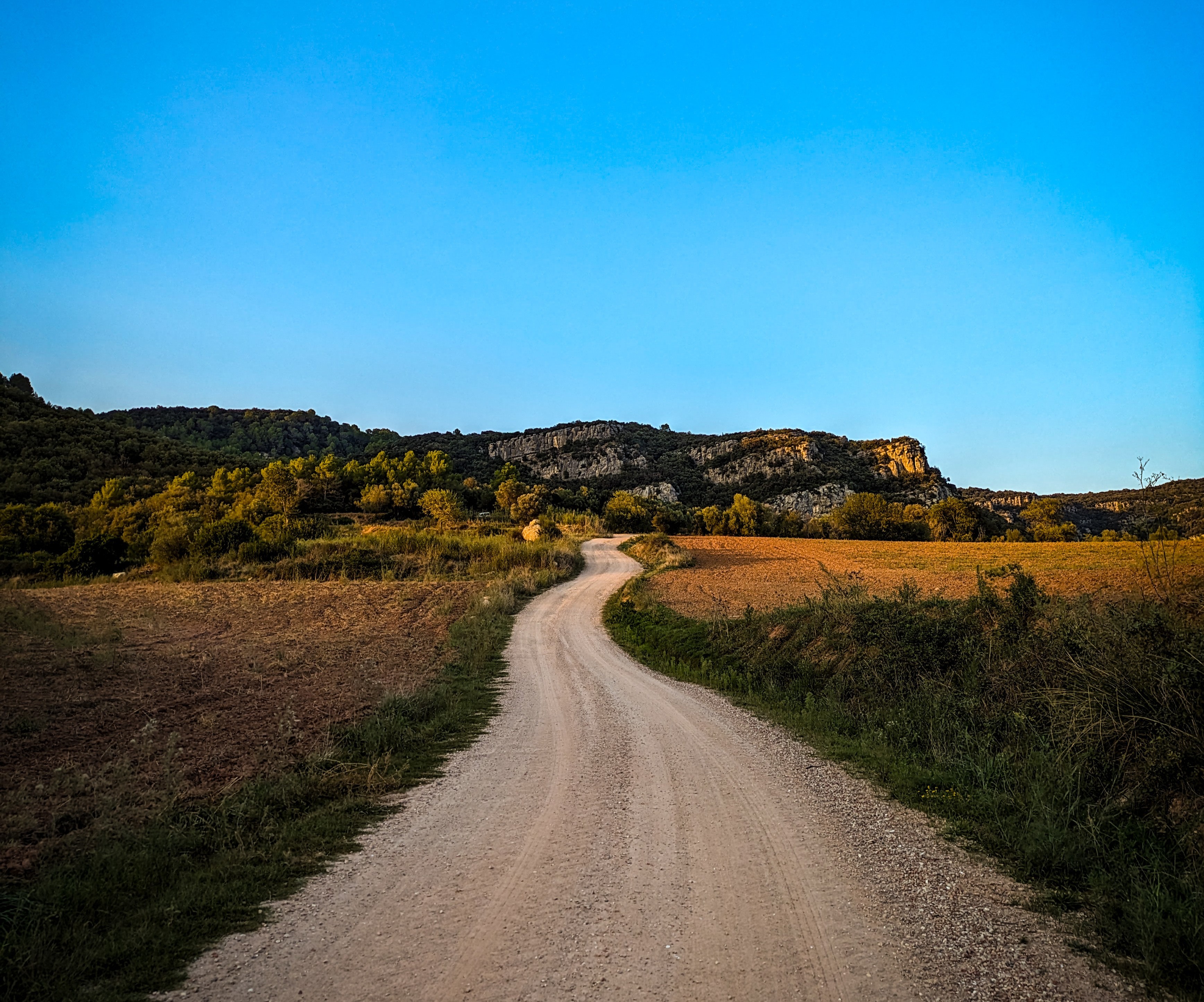 Wide desert landscape with cliffs and open sky.