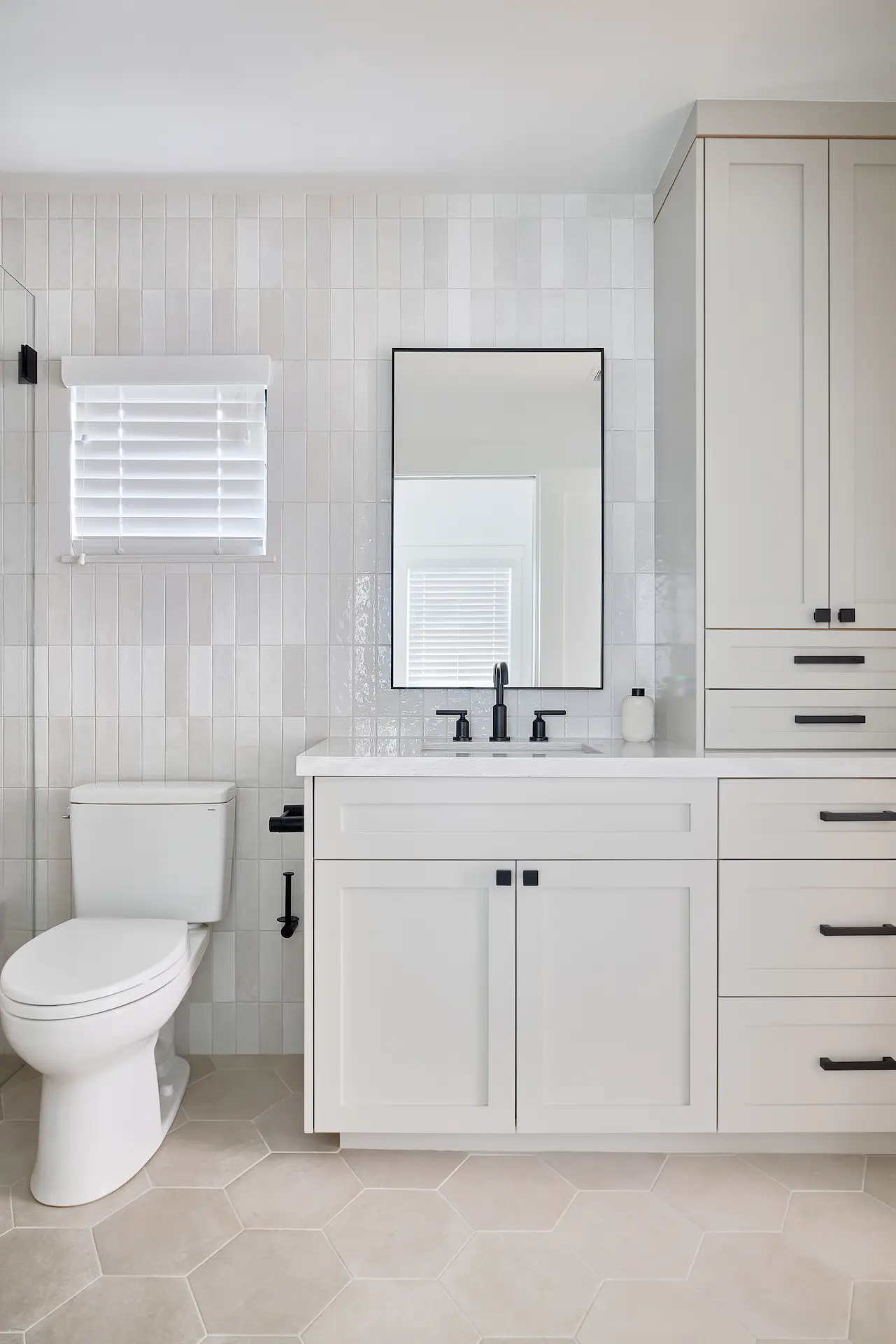 Portrait of the bathroom vanity and toilet in ADU Orange, where contemporary fixtures meet classic design sensibilities. Photo by Todd Huge.
