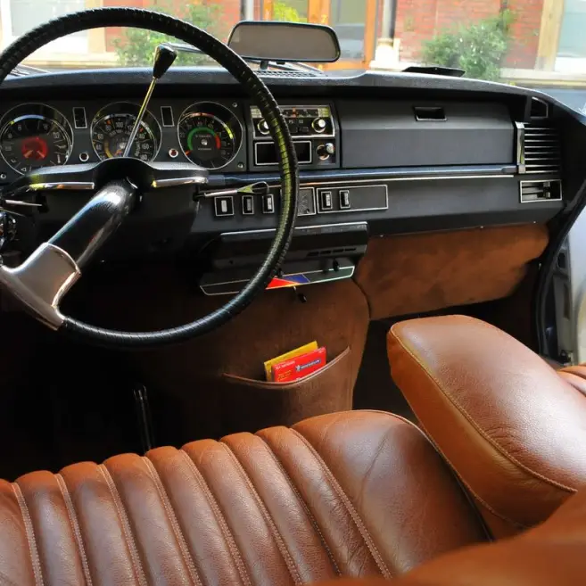 The interiro of a DS with broiwn leather seats and a black dashboard