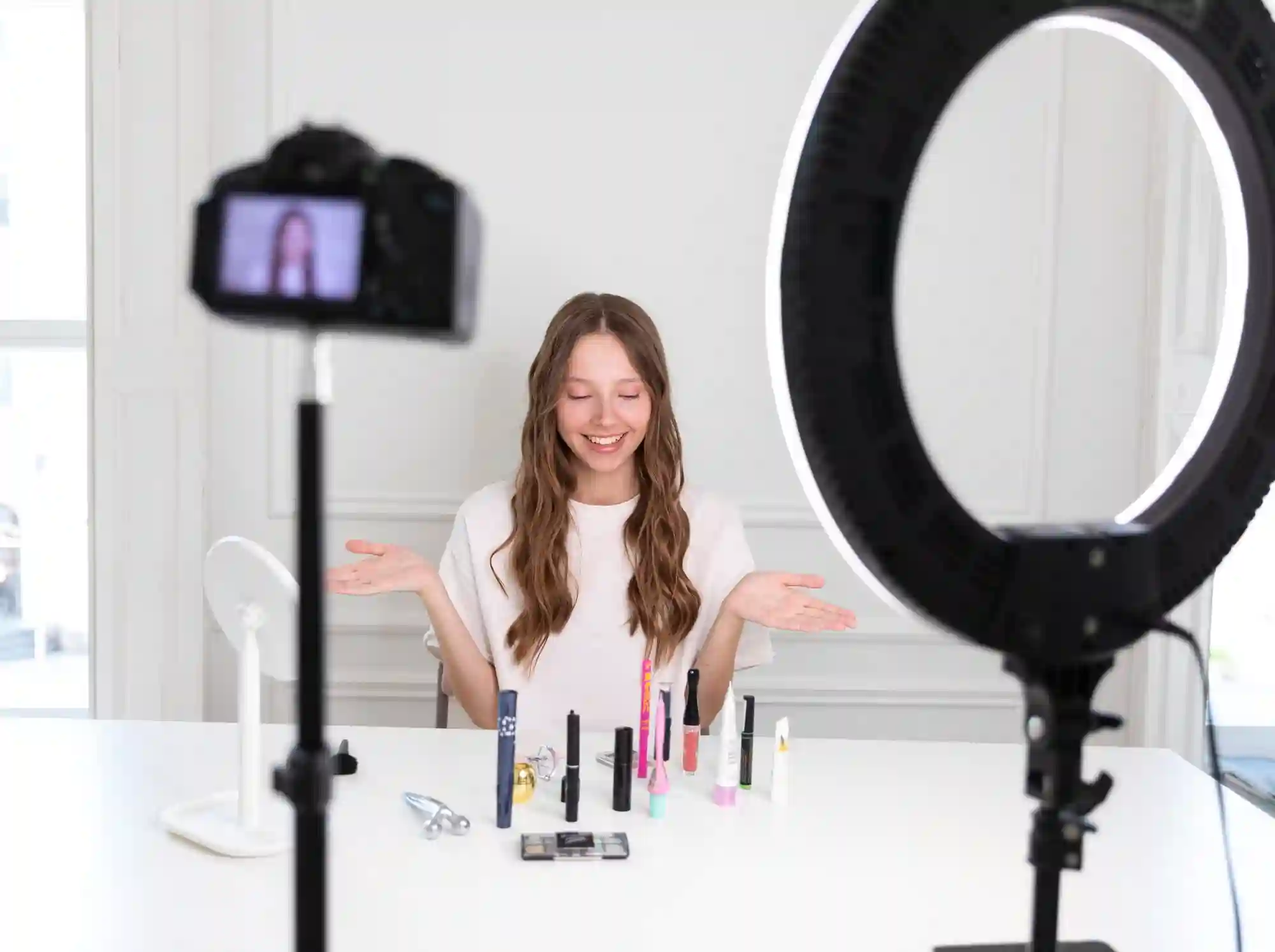 Happy creator recording a TikTok Shop video about makeup products using a ring light.