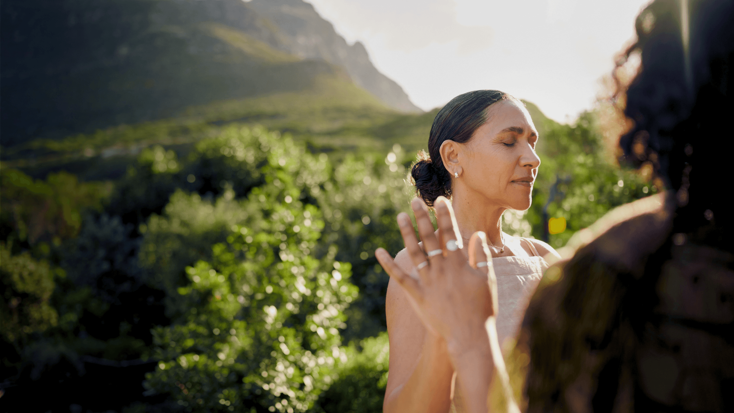 Modern living room with abstract art, beige sectional sofa, indoor plants, and large windows.