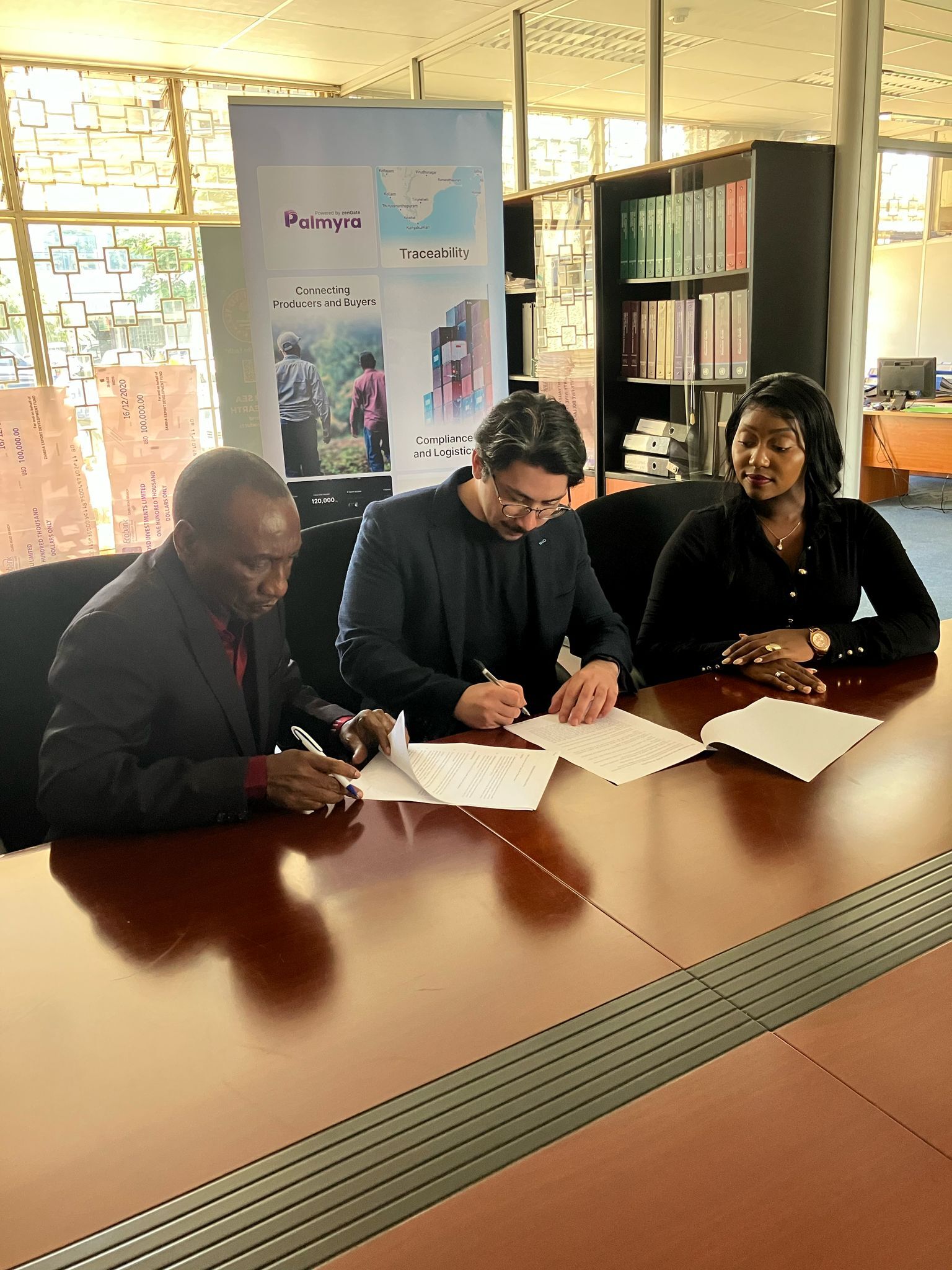 femme signant sur du papier blanc d'imprimante à côté d'une femme sur le point de toucher les documents