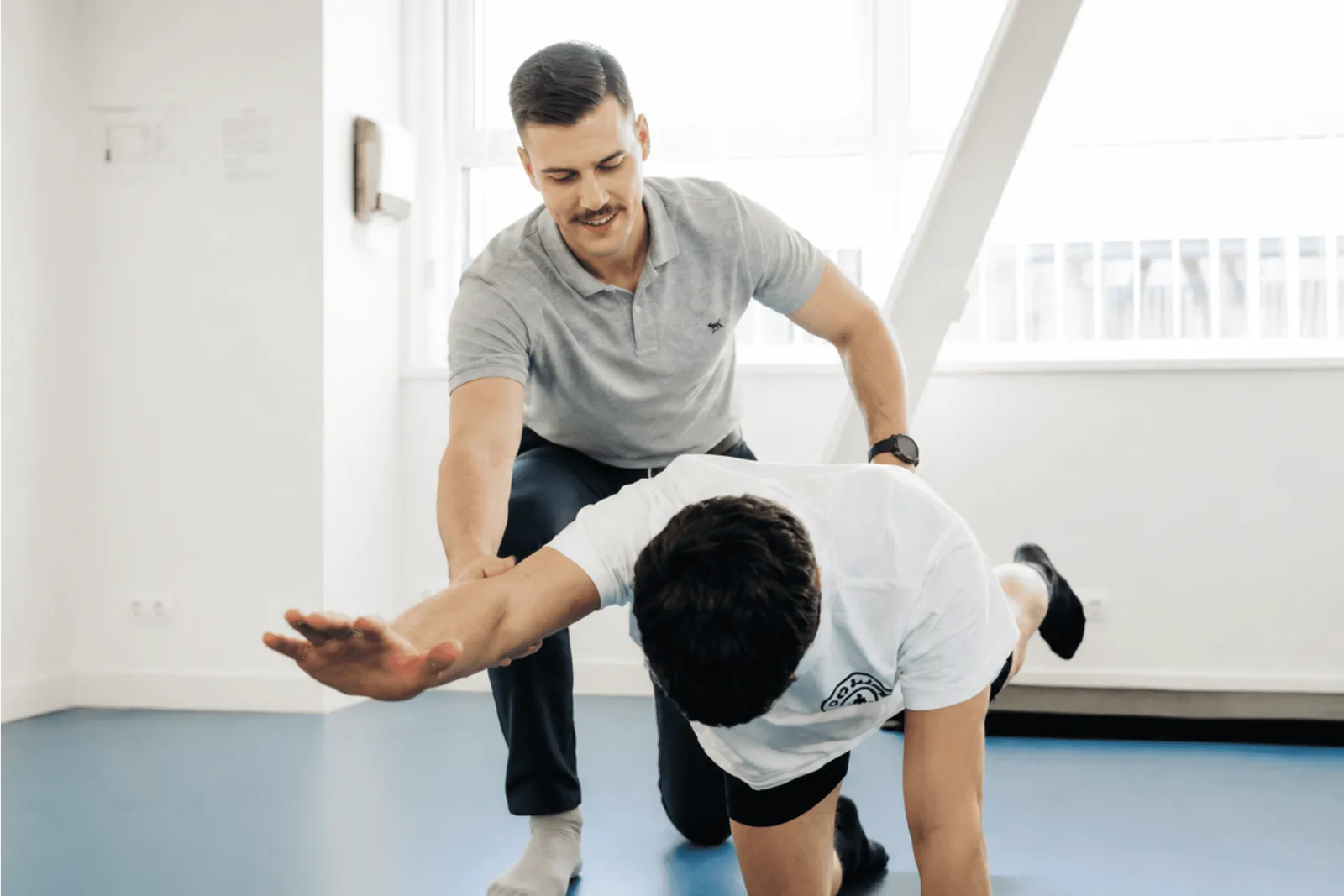 Physiotherapist guiding a client through a floor exercise