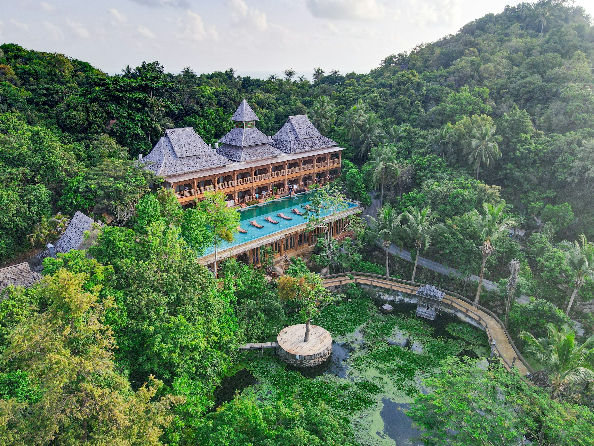 Luxury resort nestled in dense greenery with a central swimming pool