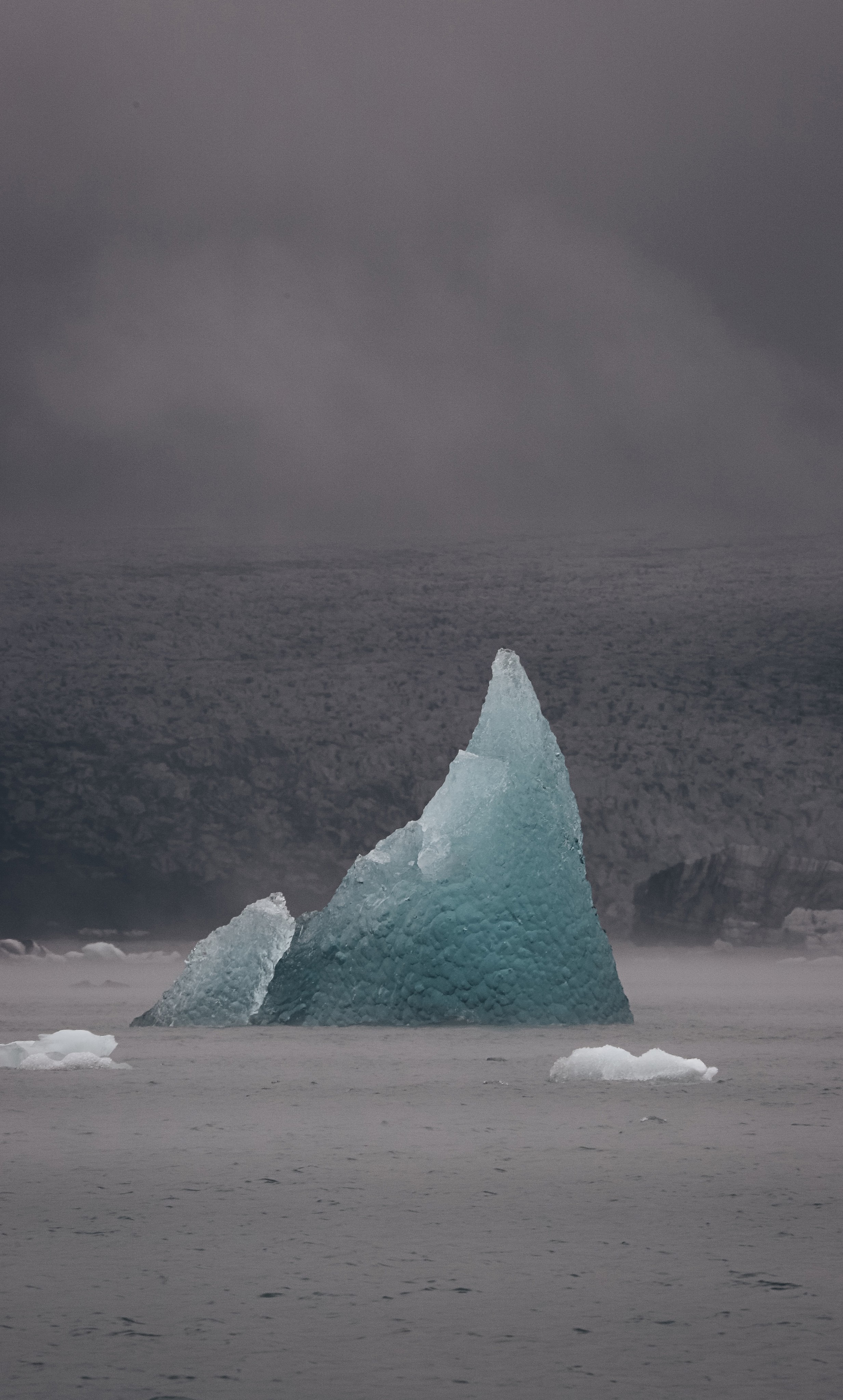 An blue iceberg in the middle of the water