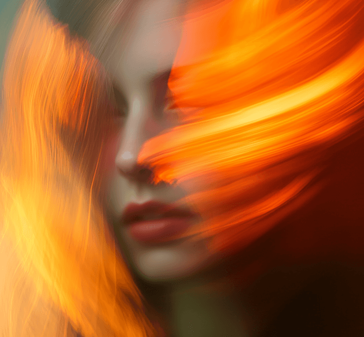 A woman with striking orange hair and a long face, posing against a neutral background with a calm demeanor.
