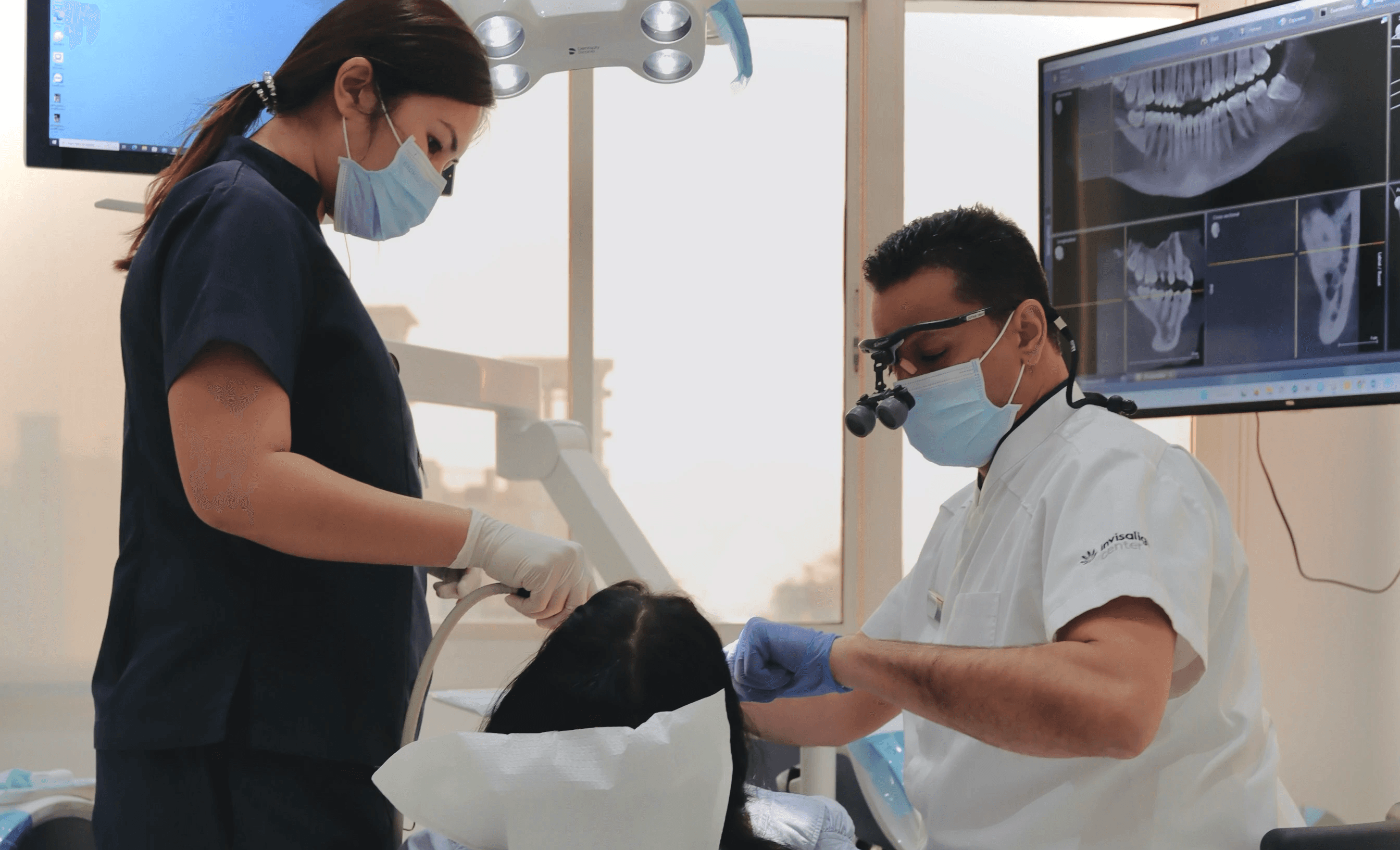 Dentist providing treatment for swollen gums while reviewing diagnostic dental images in a clinical setting.