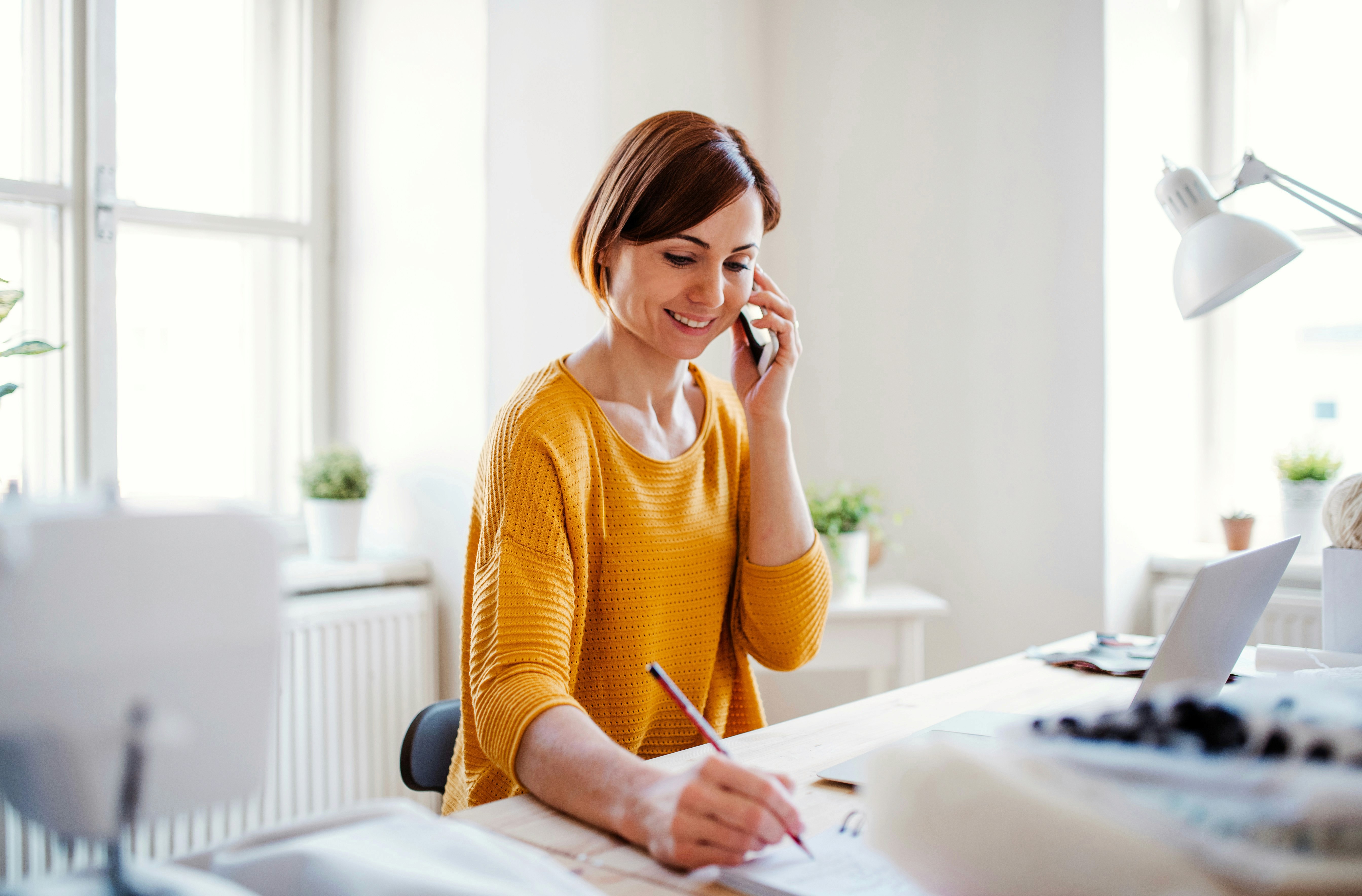 Woman on phone taking notes