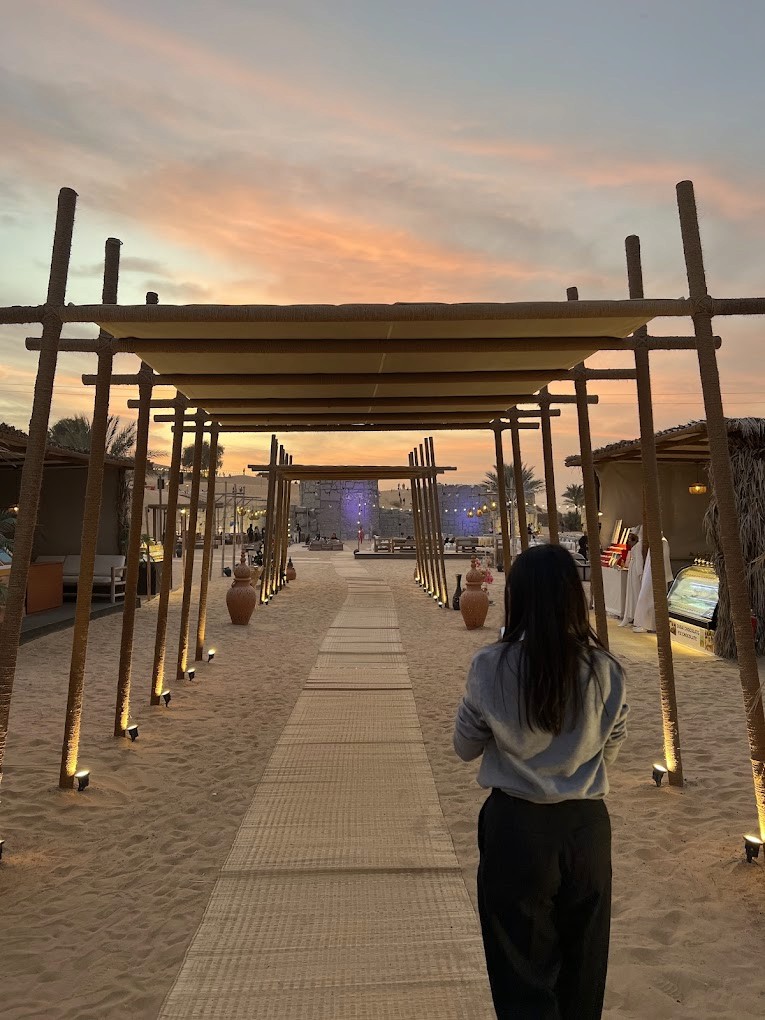 he elegant wooden walkway entrance to The Fort Al Lisaili at sunset, reflecting the exclusive and secluded atmosphere of our desert safari base